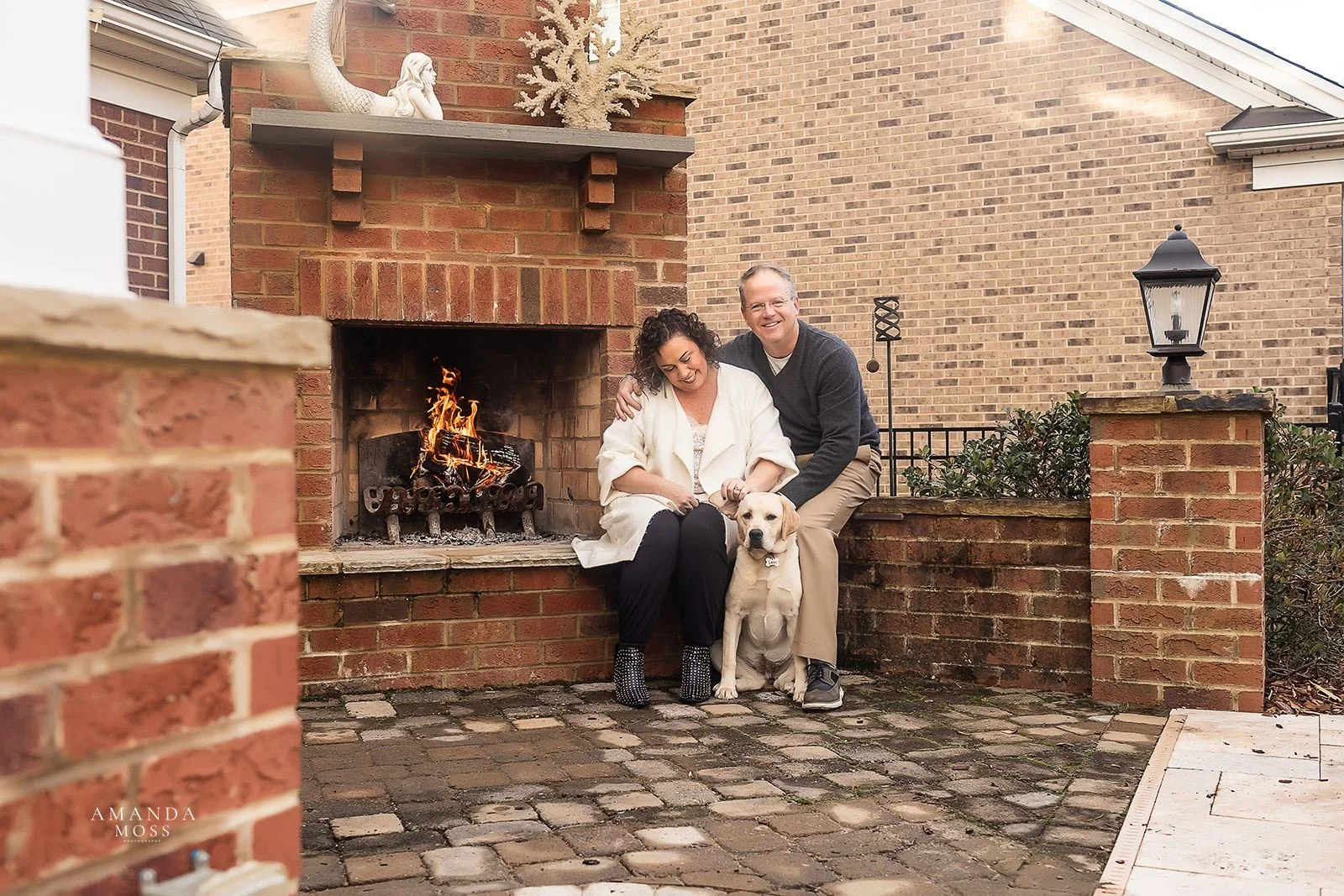 couple and their dog pose for family photo on their patio at home in charlotte nc