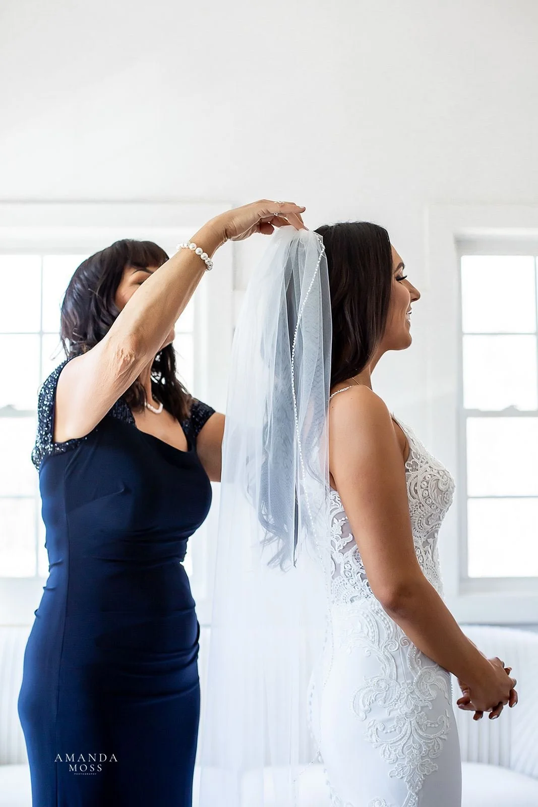 bride's mom adjusts her veil before her wedding