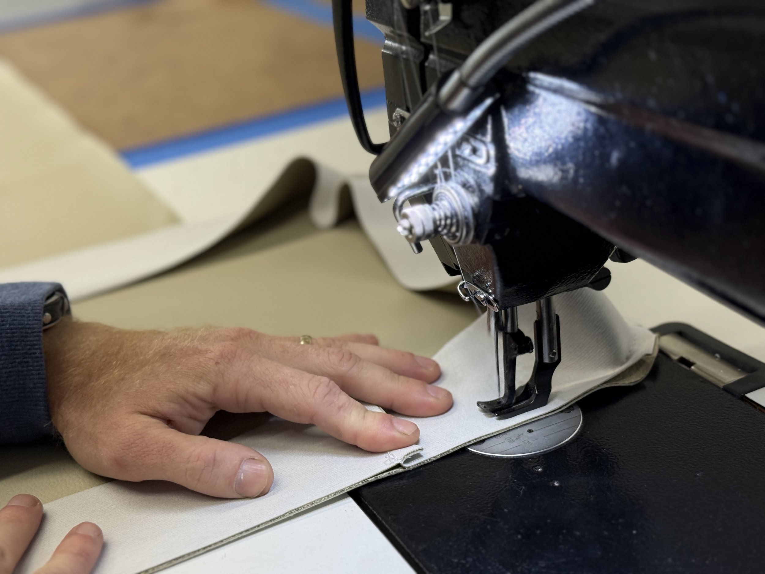 Close-up of a person's hands sewing on a sewing machine.