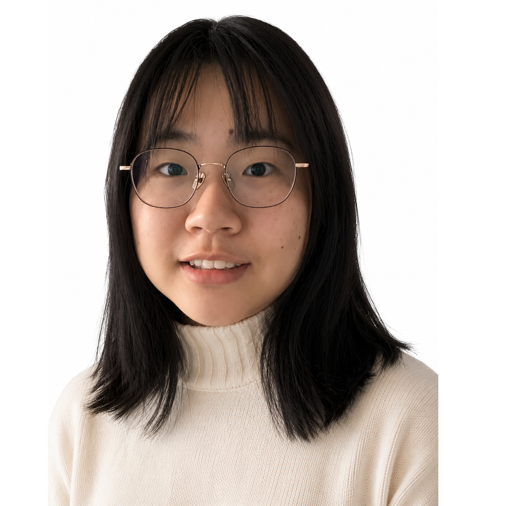 A young woman with shoulder-length black hair, wearing round glasses and a cream-colored turtleneck sweater, smiling against a white background.