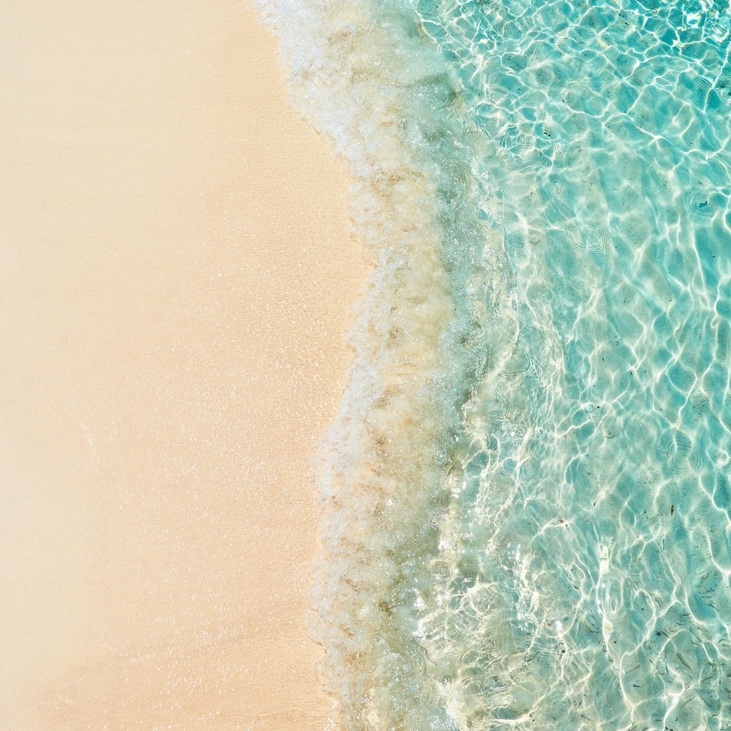 Aerial view of a turquoise beach in the Bahamas, where Kaitlyn offers virtual therapy sessions.