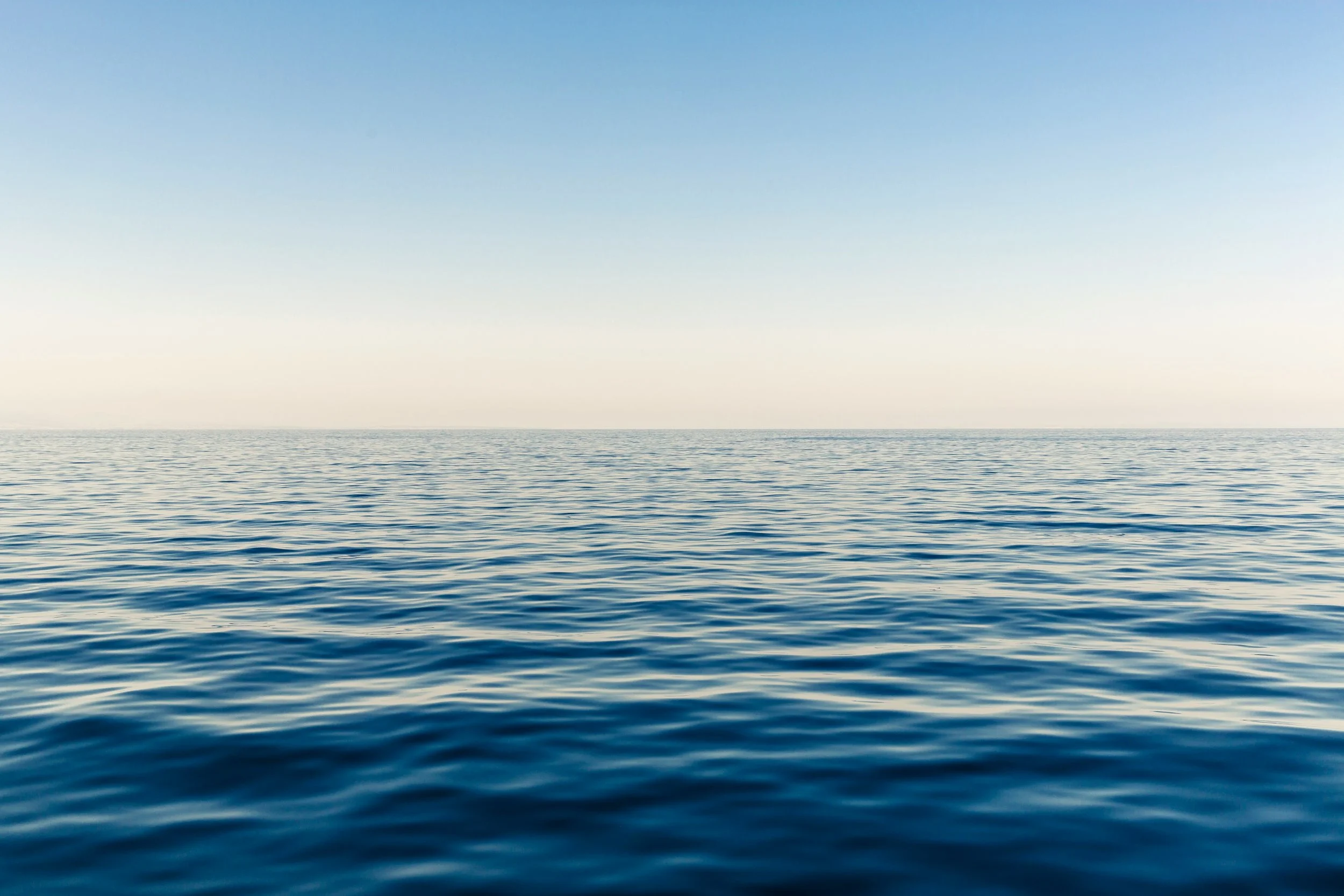 Calm ocean waters under a clear sky, evoking the peaceful, grounded feeling therapy can offer.