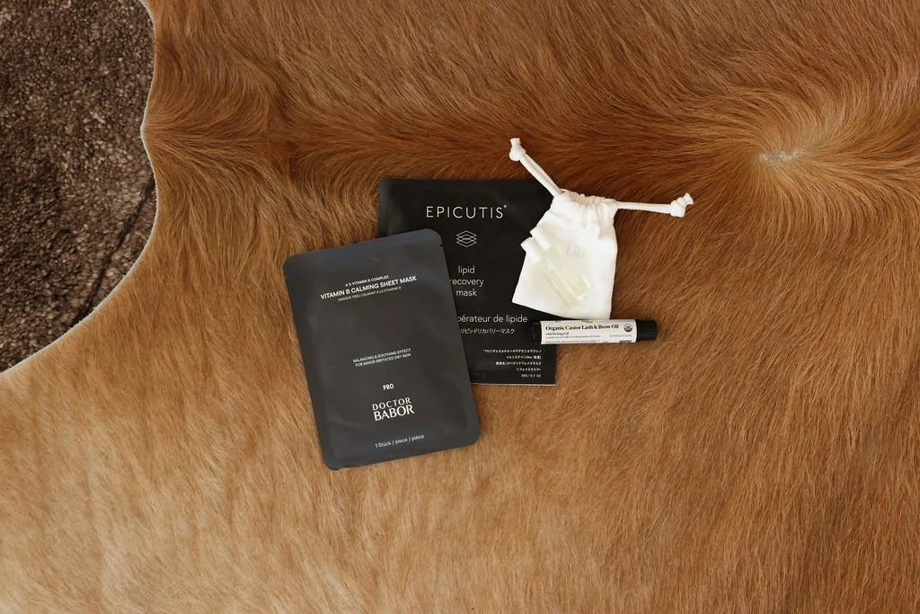 Skincare products and a small cloth pouch placed on a brown fur or hair surface.