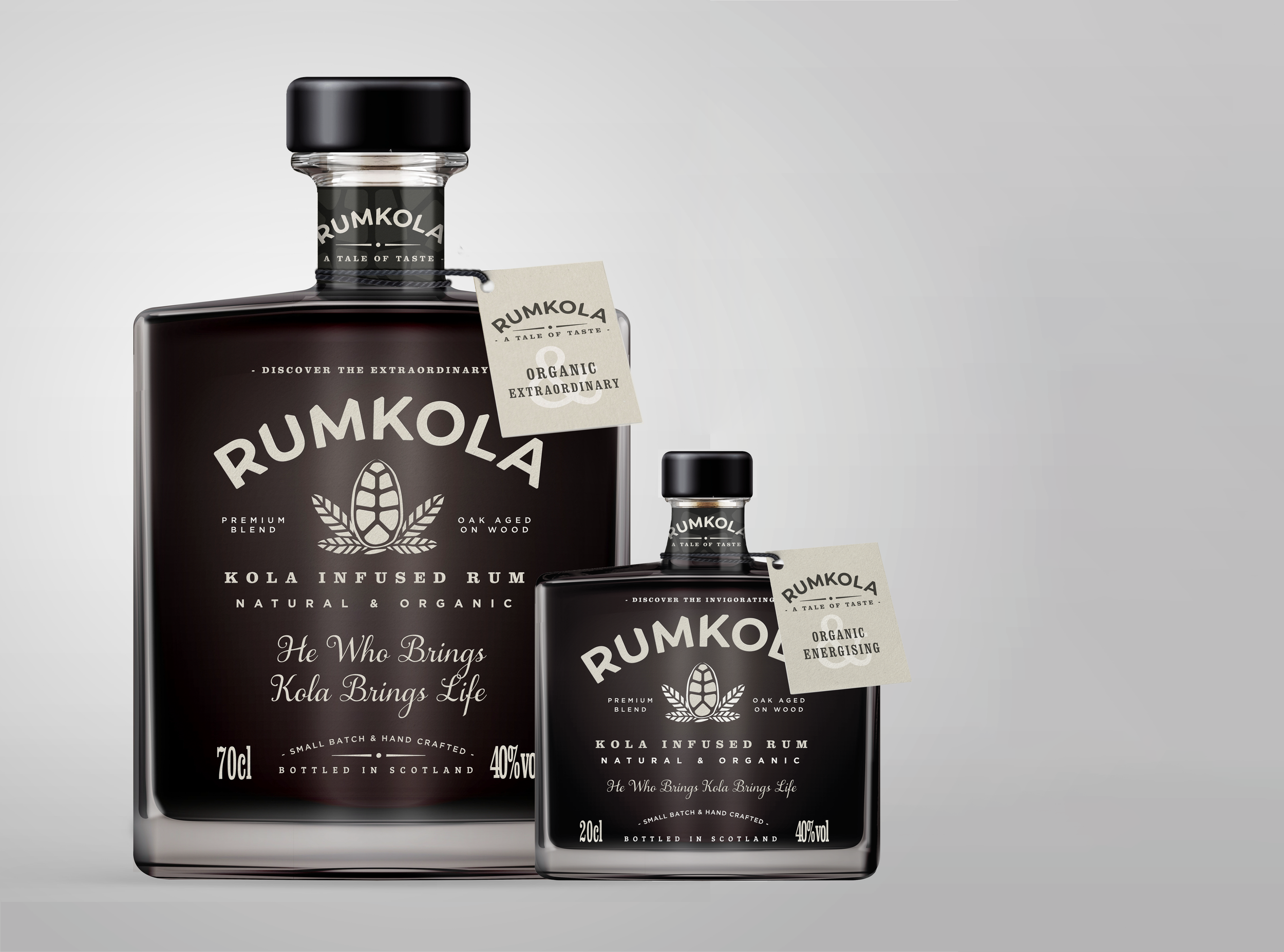 Close-up of two bottles of Rumkola, a kola-infused rum, with labels indicating organic, natural ingredients, handcrafted small batch, and bottled in Scotland, set against a neutral background.