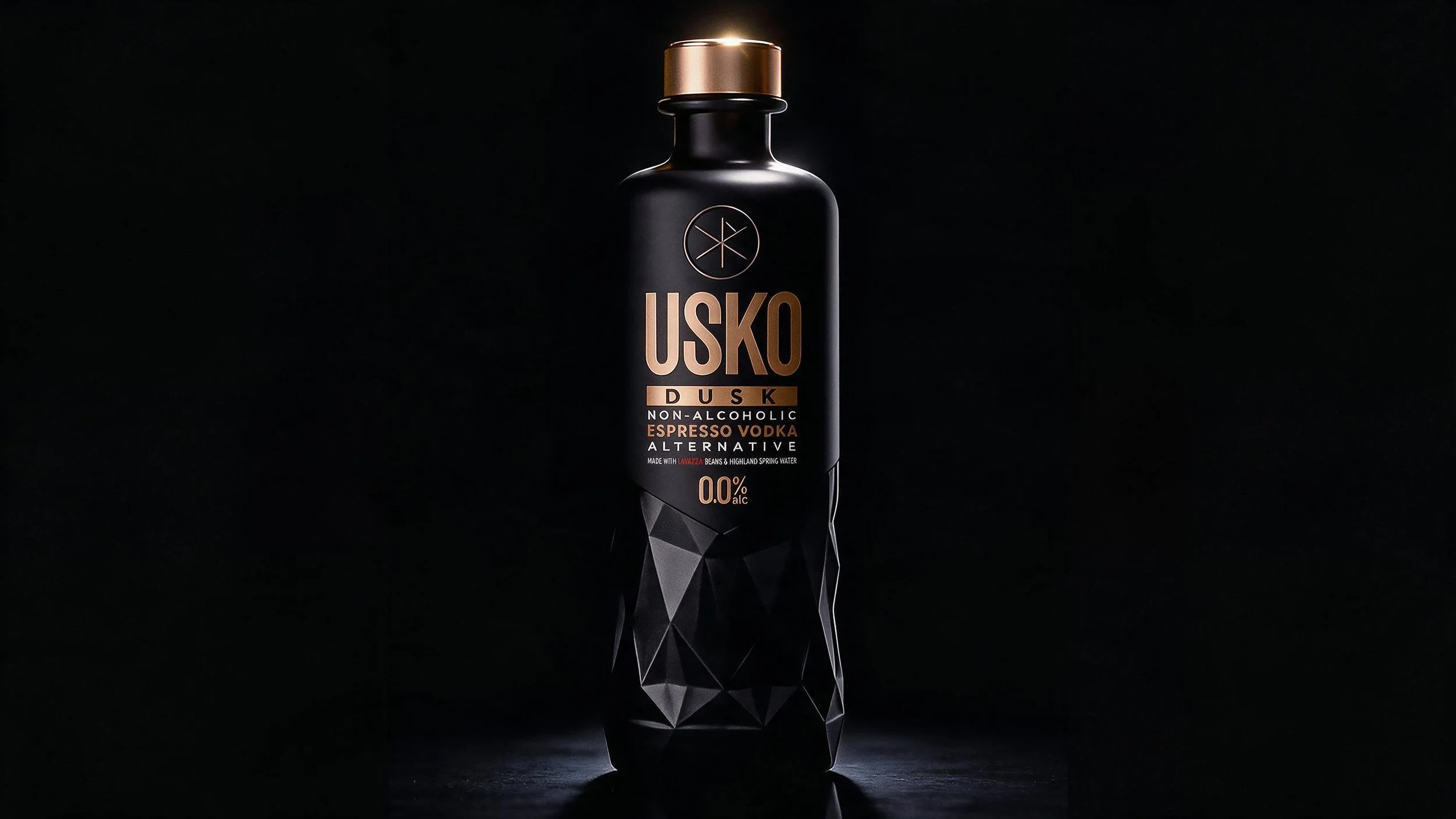A black bottle of USKO Dusk non-alcoholic espresso vodka alternative with gold accents against a dark background.