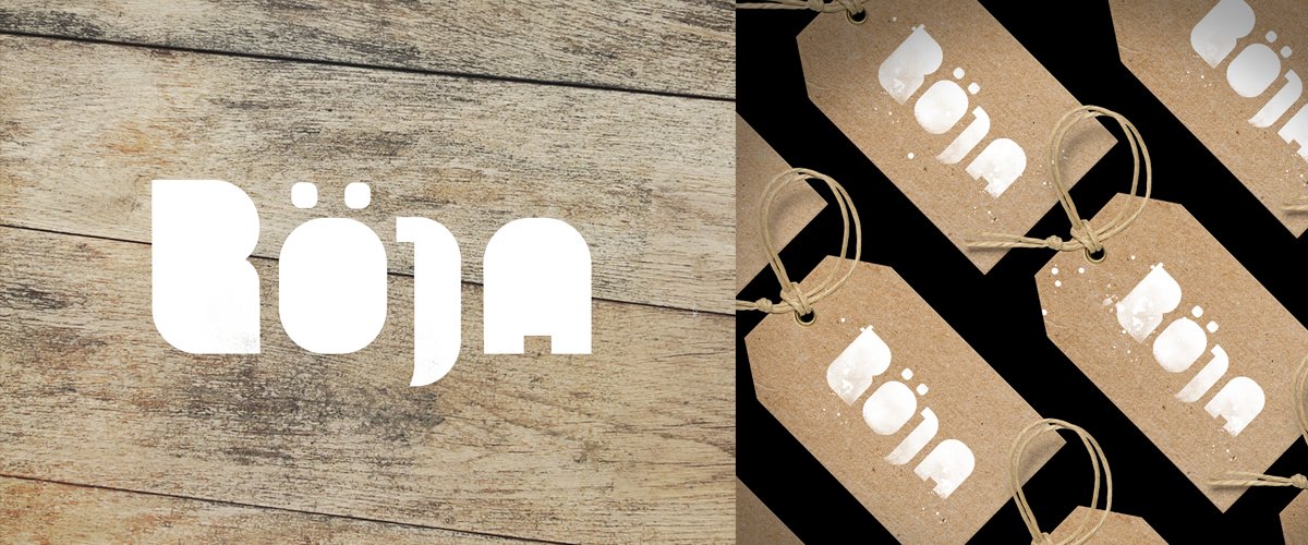 Multiple paper tags with cutouts of the word 'Bon' in white, attached to twine, with a background of wooden surface and a cardboard backing.