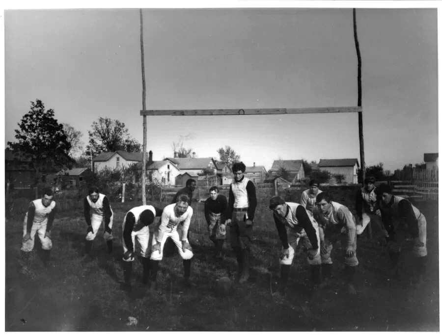 Howell High School football team posed beneath a wooden goalpost in early fall 1895, with Coach George Jewett fifth from the left.