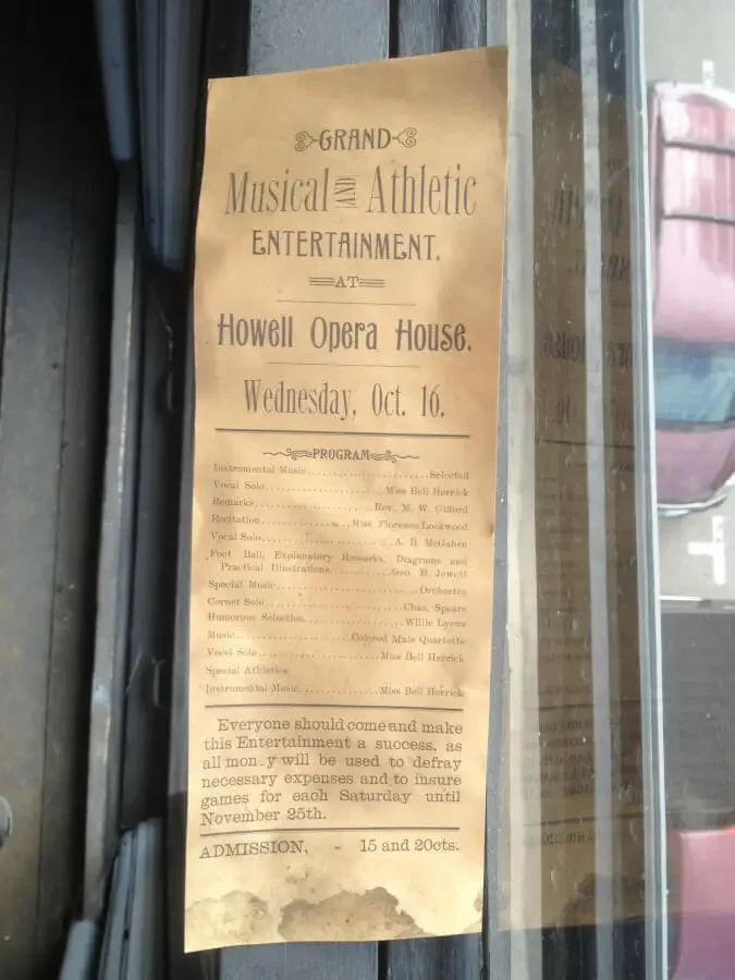 Original 1895 Howell Opera House program advertising a “Grand Musical and Athletic Entertainment” on Wednesday, Oct. 16, displayed behind glass.