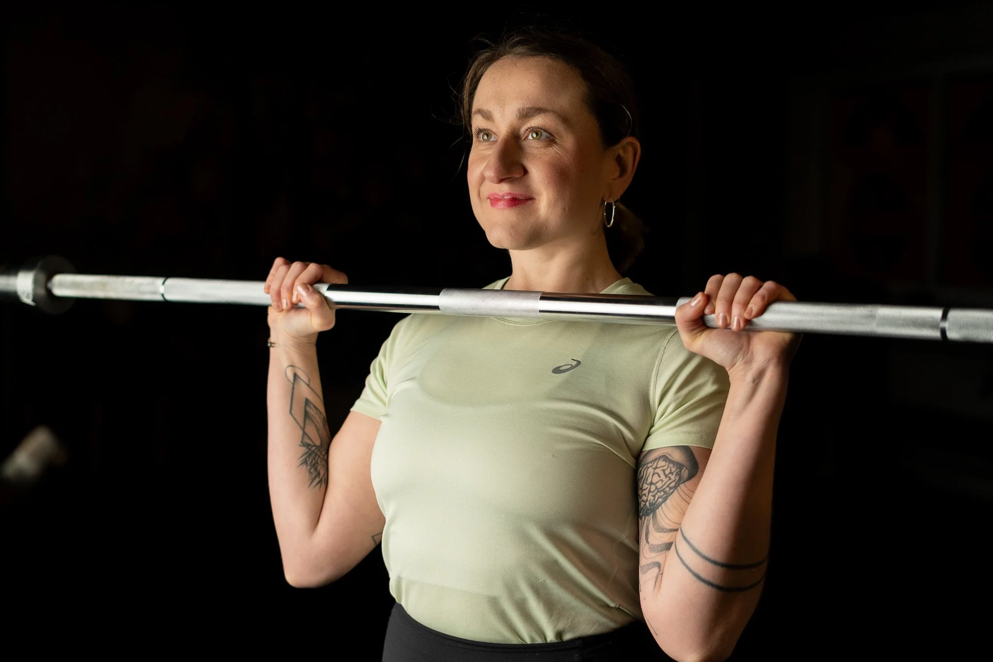 Marina Tkalcic holding a barbell in front of her chest.