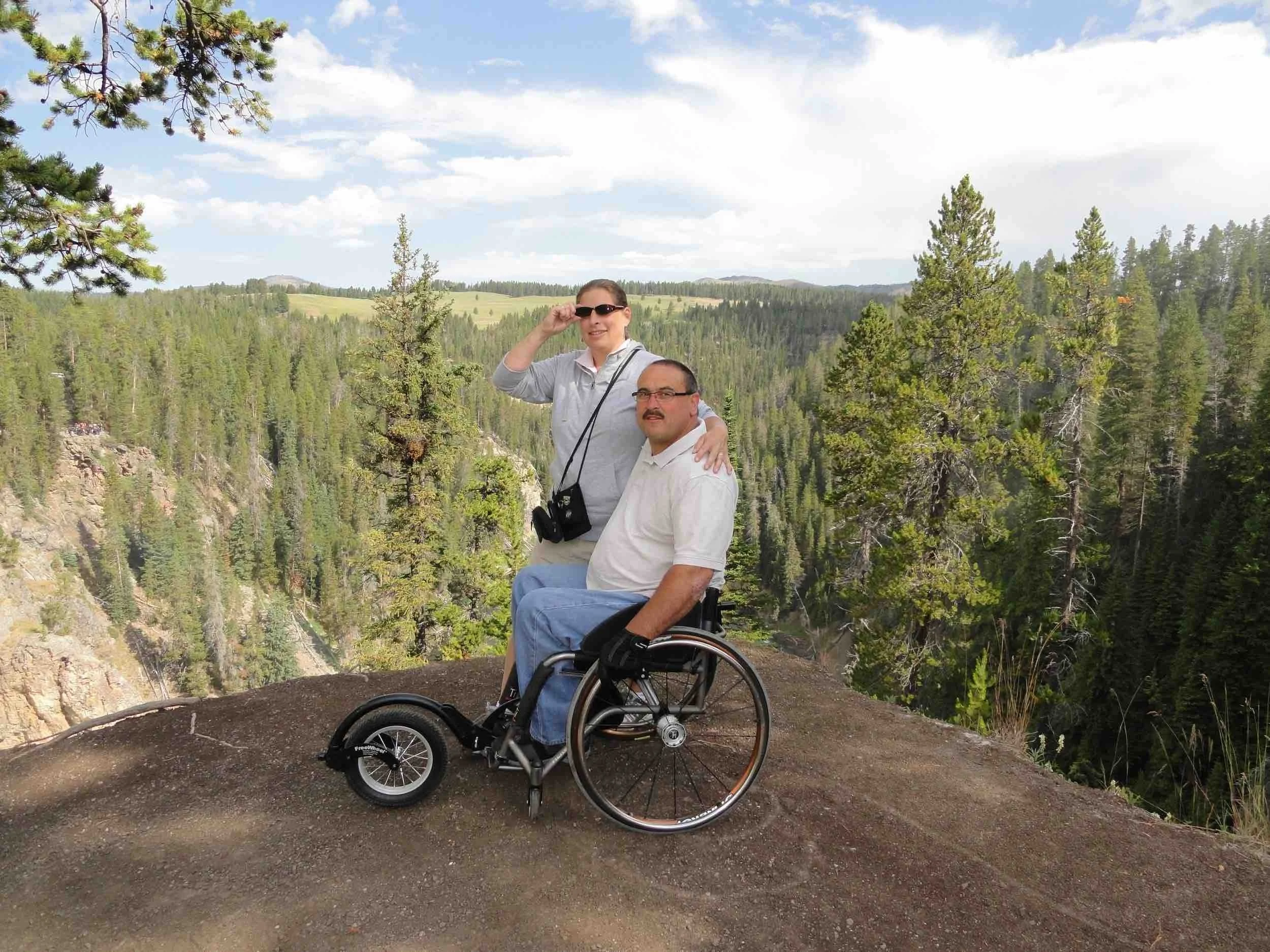 Mike Shultz and his wife share a moment at a scenic mountain overlook, highlighting resilience, love, and accessible travel.