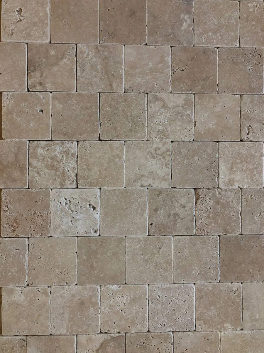 Mur en pierre beige avec des carreaux rectangulaires disposés en rangées
