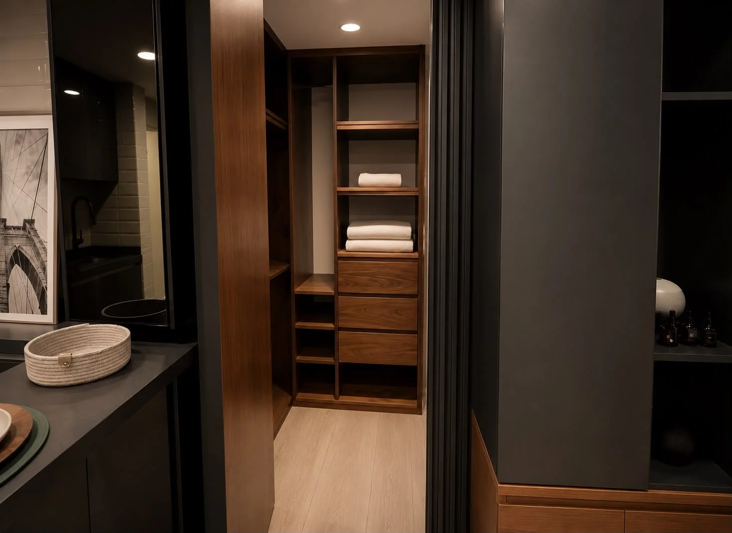 Wooden shelving unit with towels and open compartments in a modern interior.