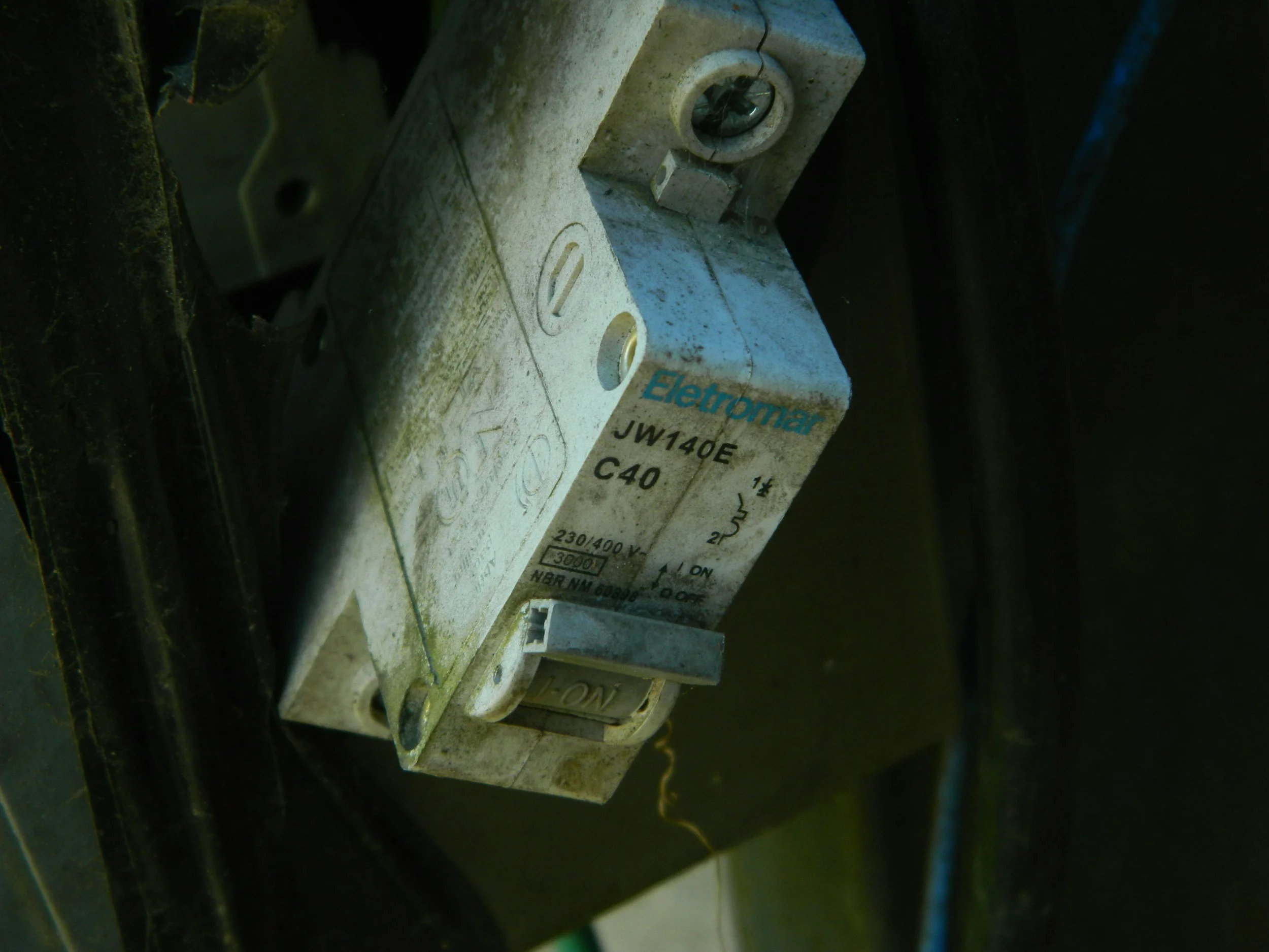 Close-up of an electrical or mechanical component labeled 'Electron,' with a model number 'JW14Q0 C40', showing a metallic surface with some dirt and grime.