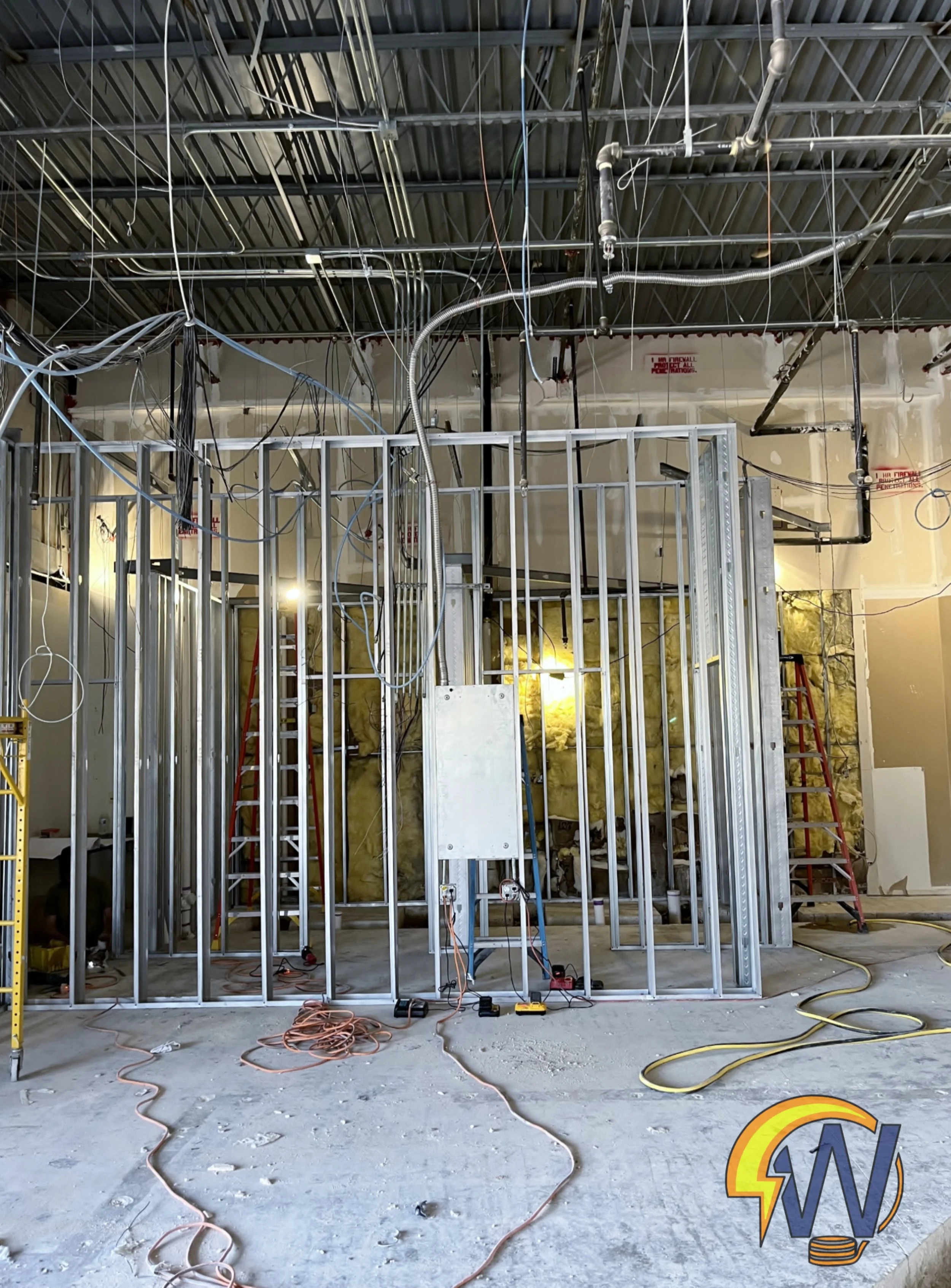 Construction site showing metal framing and exposed wiring for an interior building renovation.