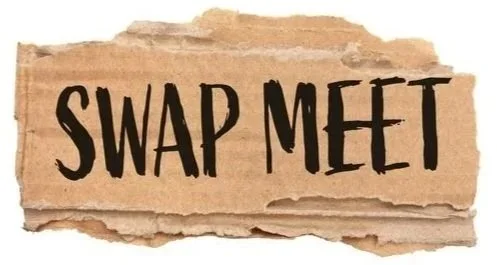 A torn piece of brown paper with the words 'SWAP MEET' written in black, capital letters.