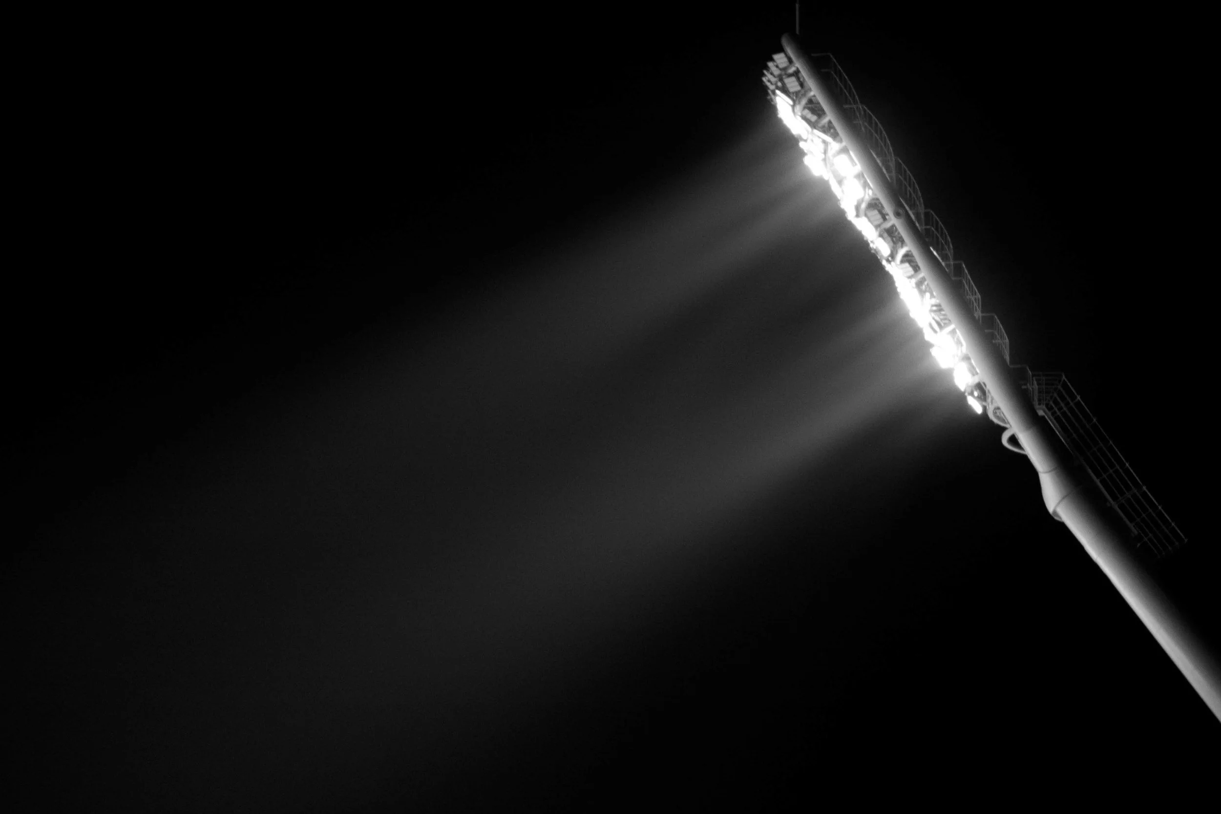 Stadium lights pointing onto a dark background