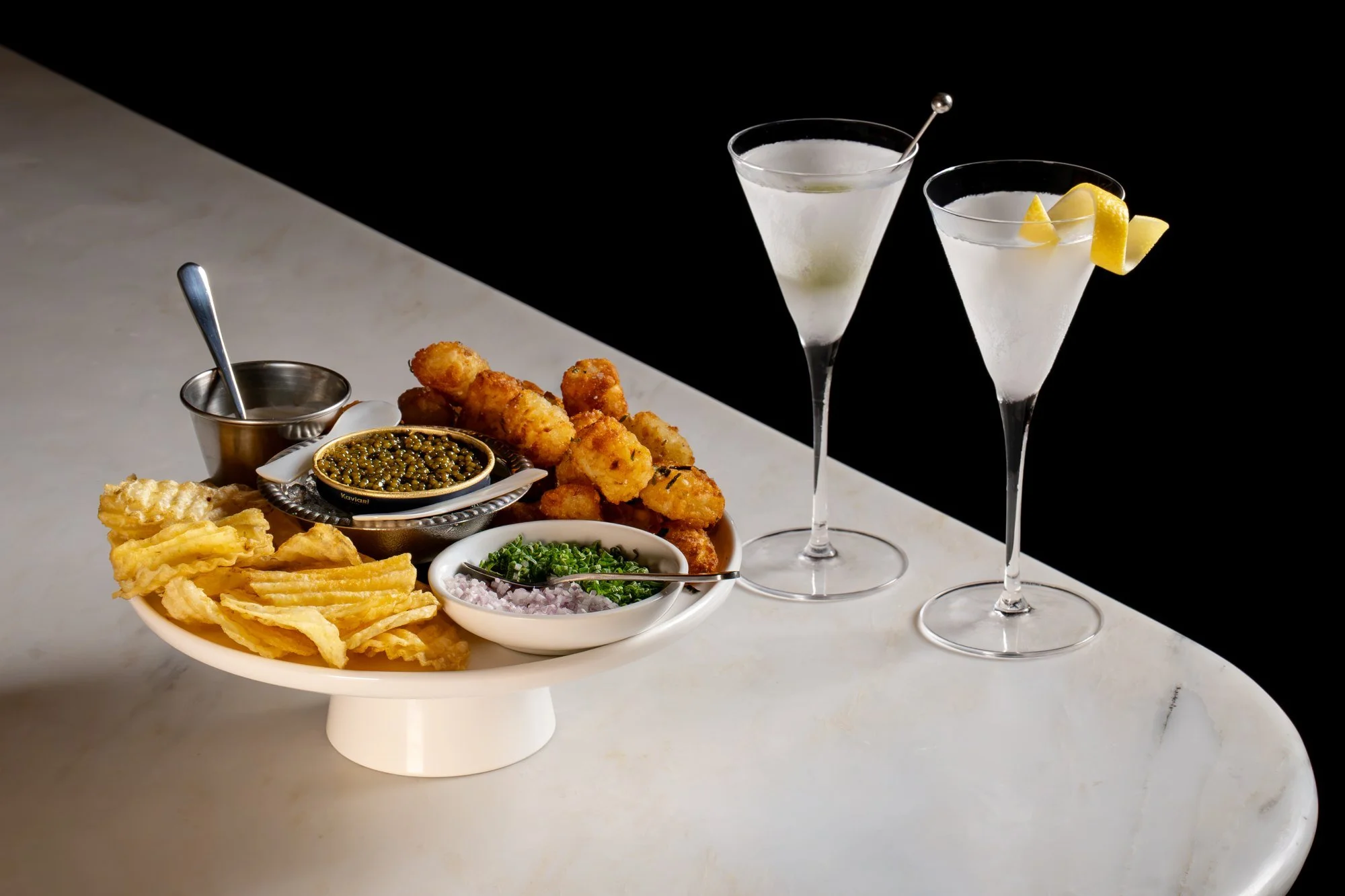 Two martinis served with caviar and bar snacks