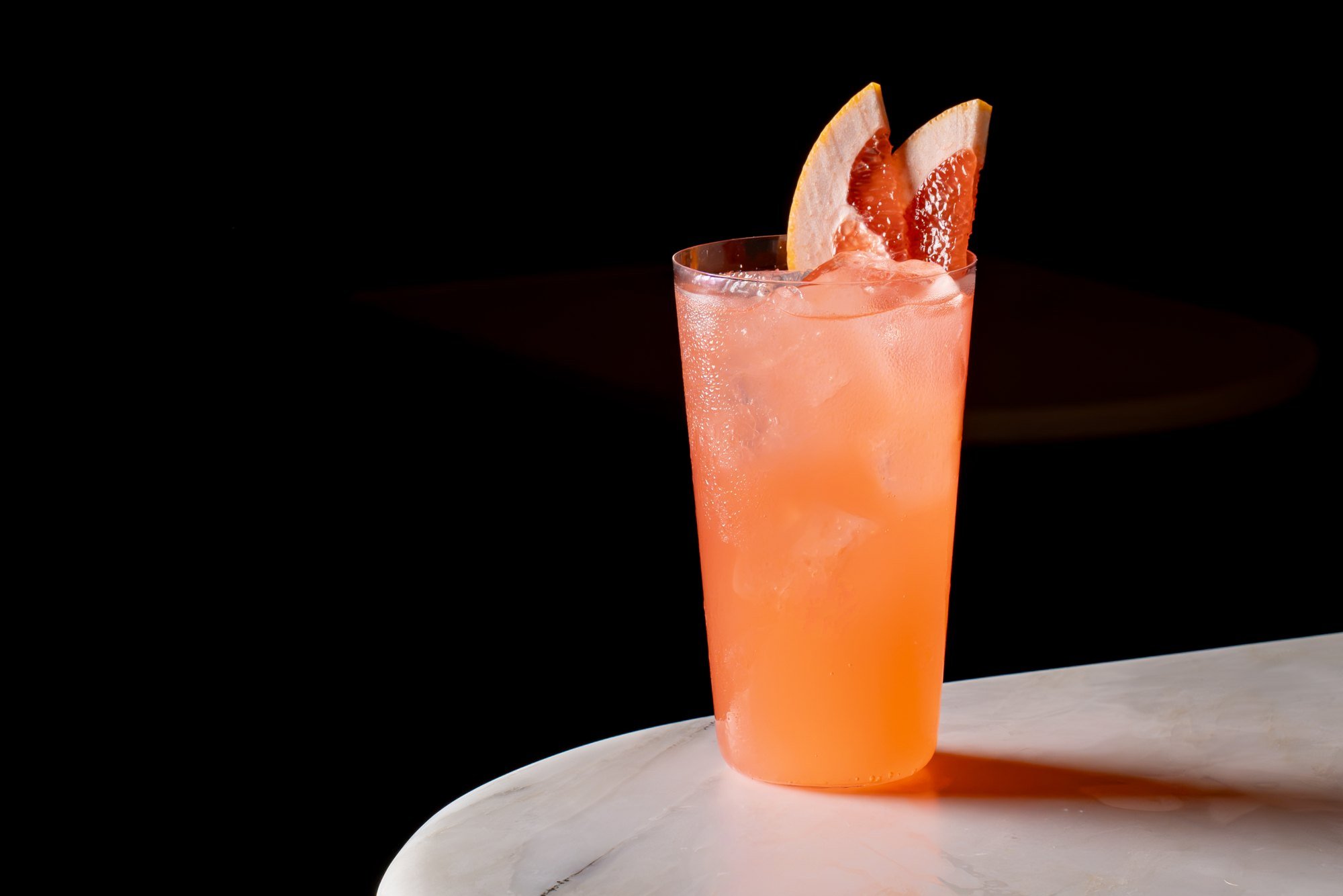 Pink grapefruit highball garnished with a grapefruit wedge