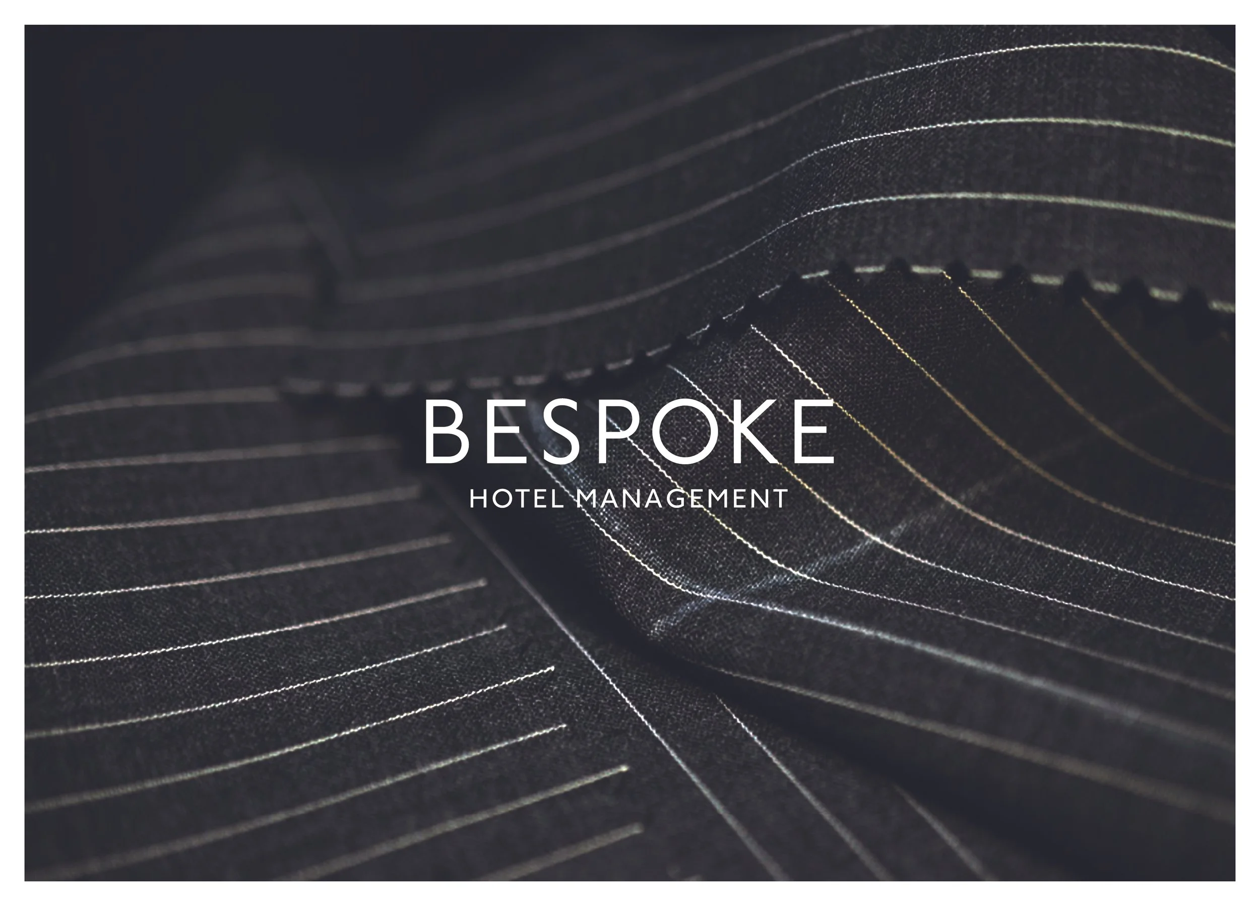 Close-up of black fabric with thin, parallel, light-colored lines, and the text "BESPOKE HOTEL MANAGEMENT" overlayed.