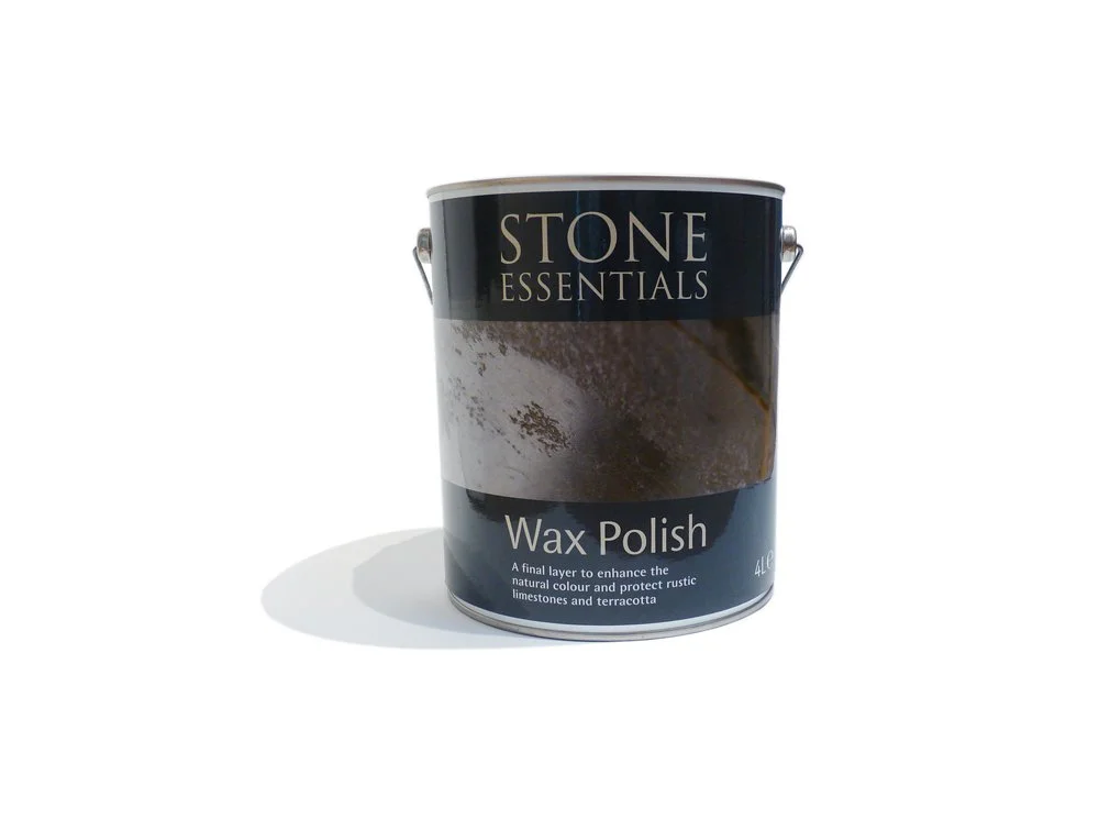 A can of Stone Essentials wax polish with a black and brown label, sitting on a white surface with shadow, intended for polishing limestone and terracotta surfaces.