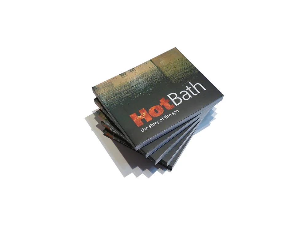 A stack of brochures for Hot Bath spa with the slogan "the story of the spa"