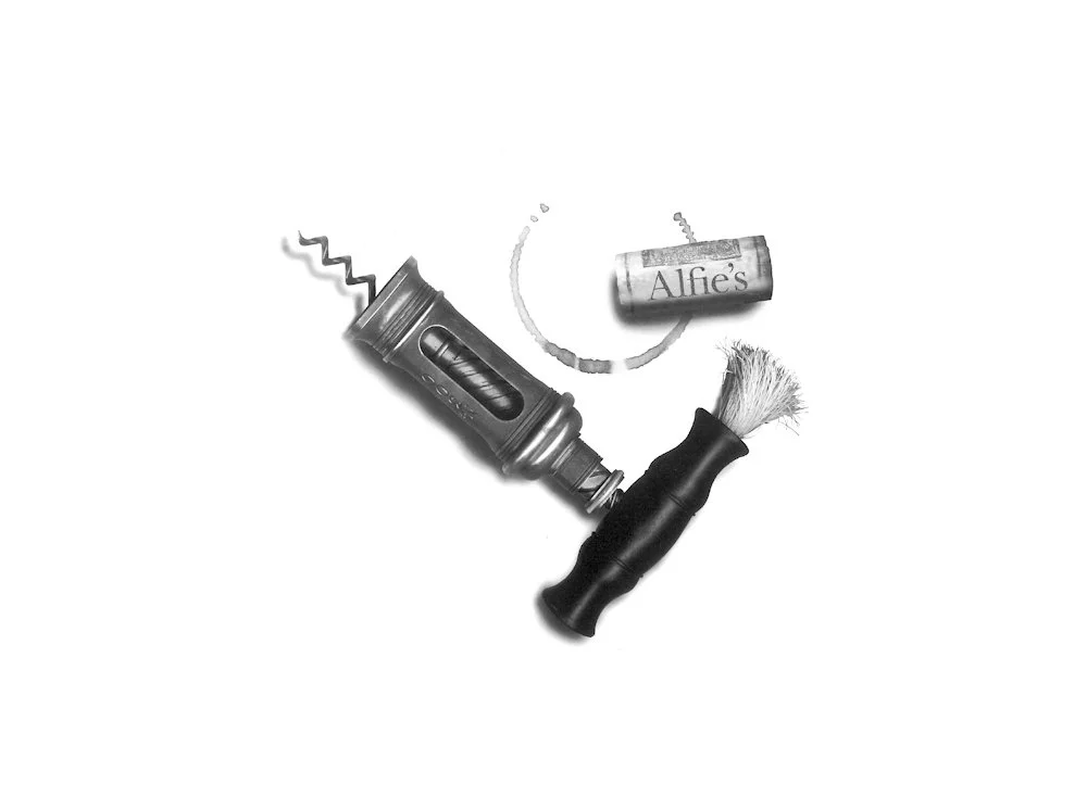 A collection of shaving items including a straight razor, a shaving brush, a tube of shaving cream, and a razor blade.