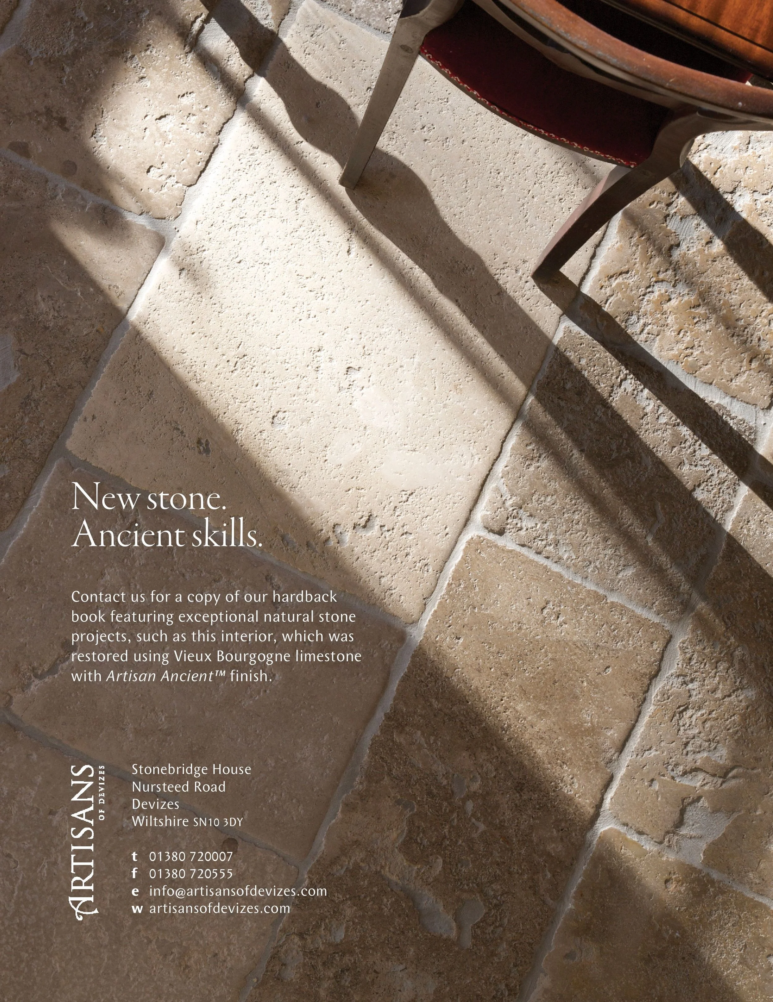 Close-up of a floor made of natural stone tiles in beige and brown tones, with text overlay providing contact and project information for Artisans of Devizes, featuring details about their restoration work using Vieux Bourgogne limestone with Artisan