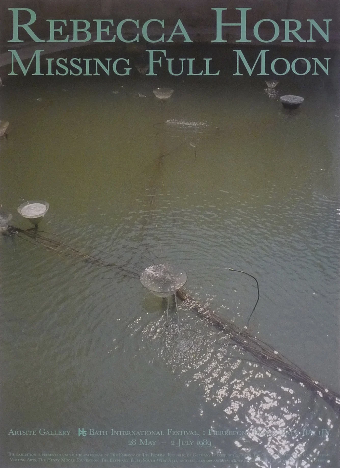 A poster showcasing an art exhibition titled "Missing Full Moon" by Rebecca Horn at Bath International Festival, held from May 28 to July 2, 1989. The background features a dark surface with small circular lamps or lights and some wires.