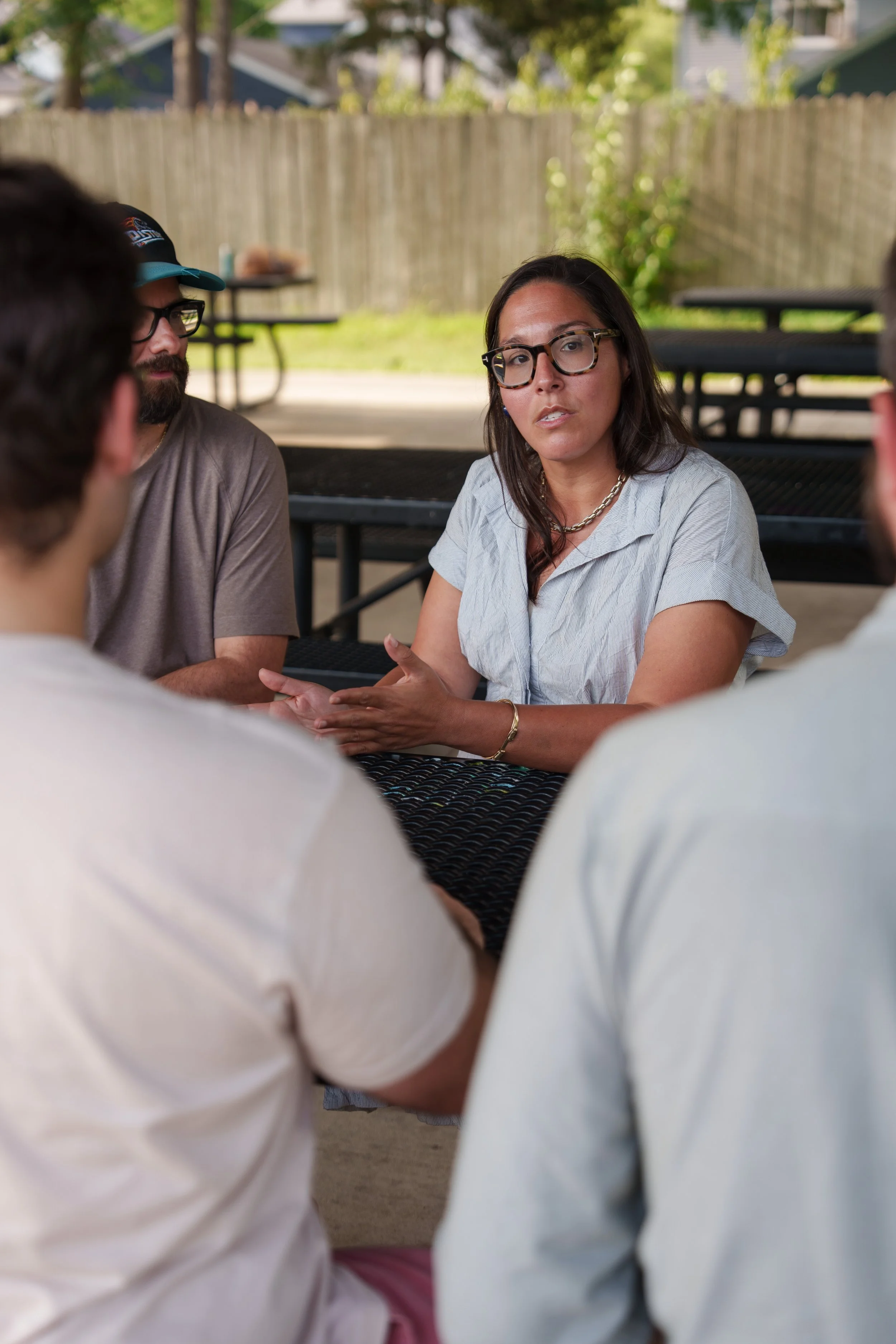 Jessica sitting with Ferndale residents on a shaded picnic table