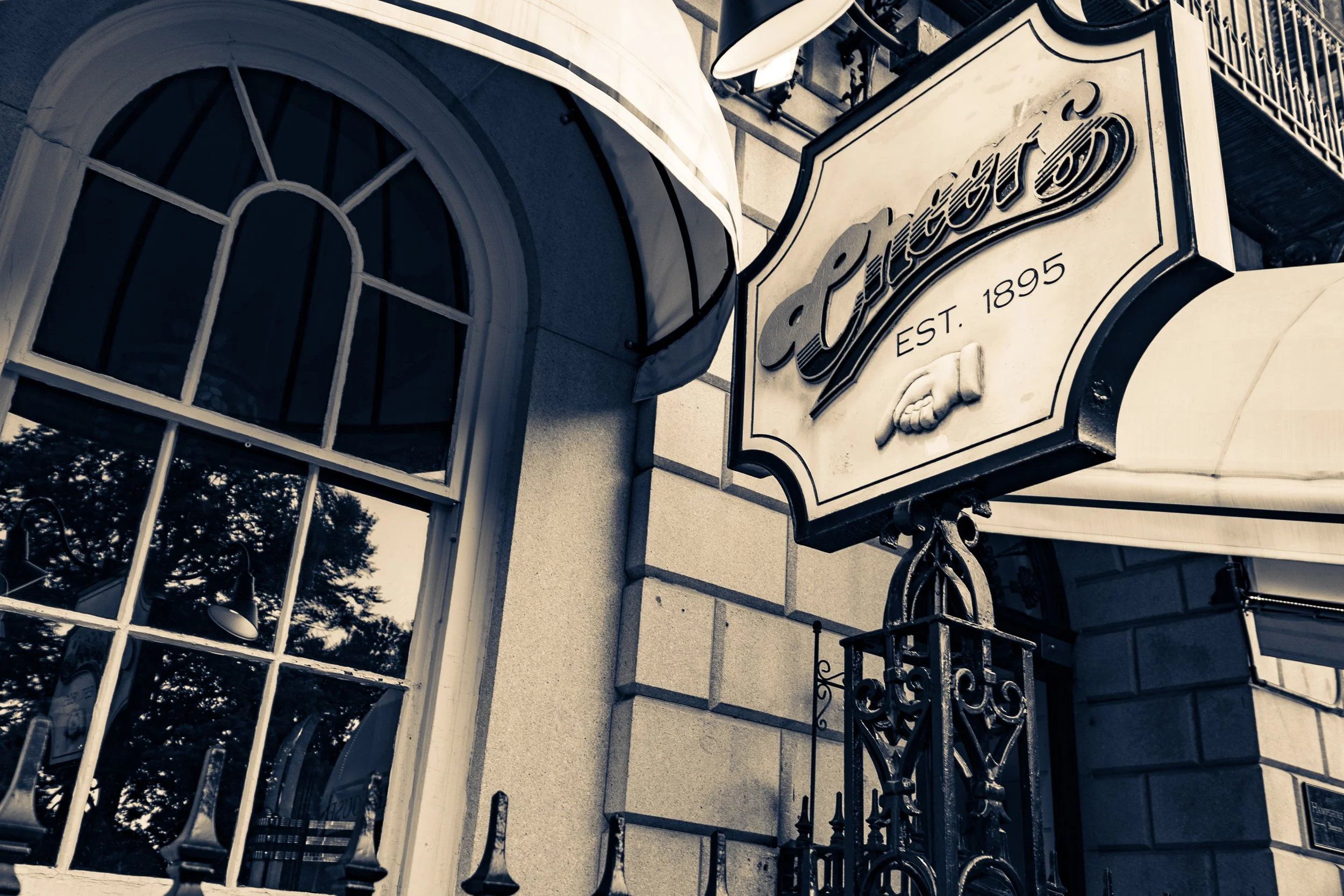 Exterior of a building with a sign that reads "Catterson EST. 1895" and a decorative iron gate, seen from below.