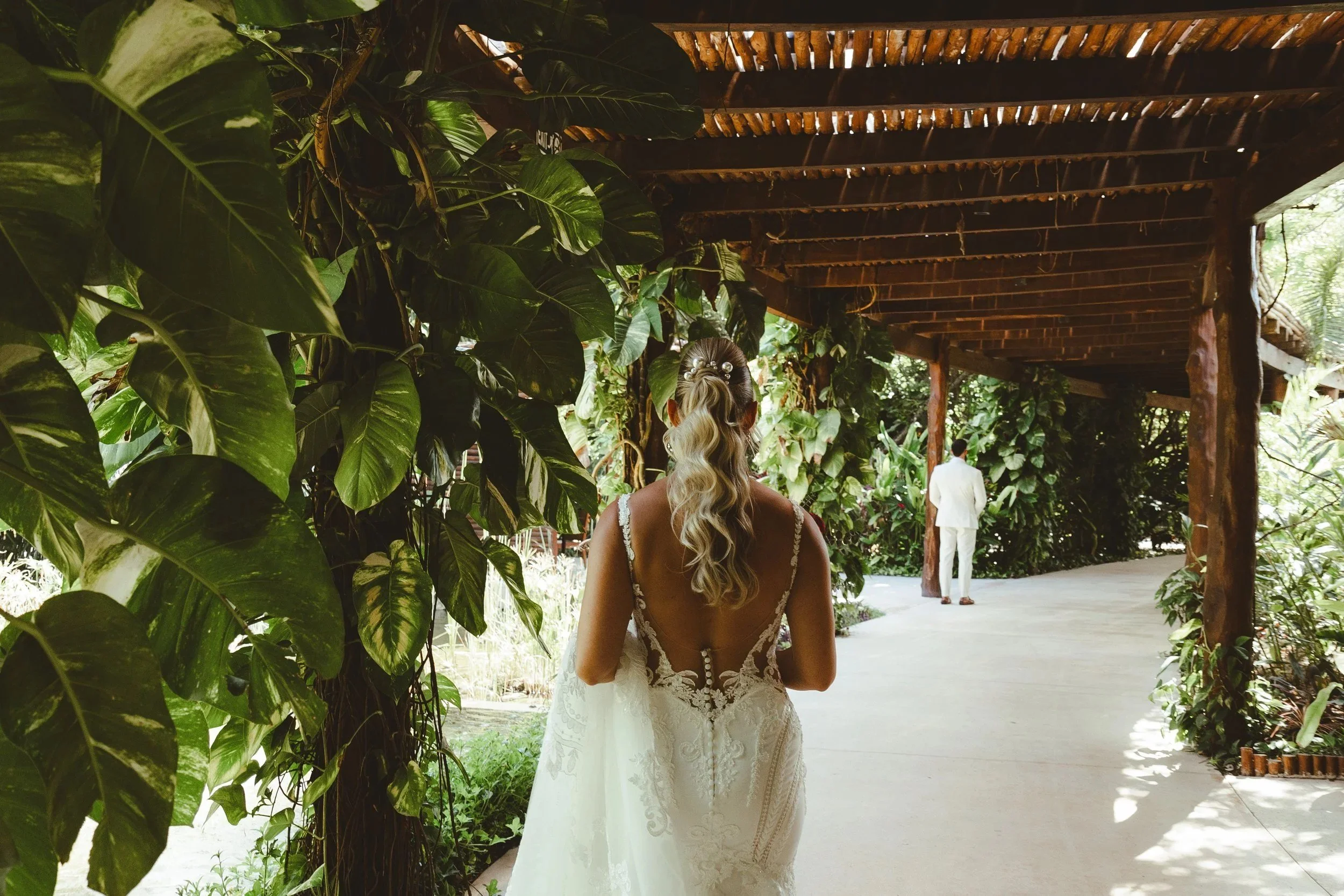 an elegant bride waiting to be seen by her husband to be during their first look at secrets akumal before their wedding ceremony