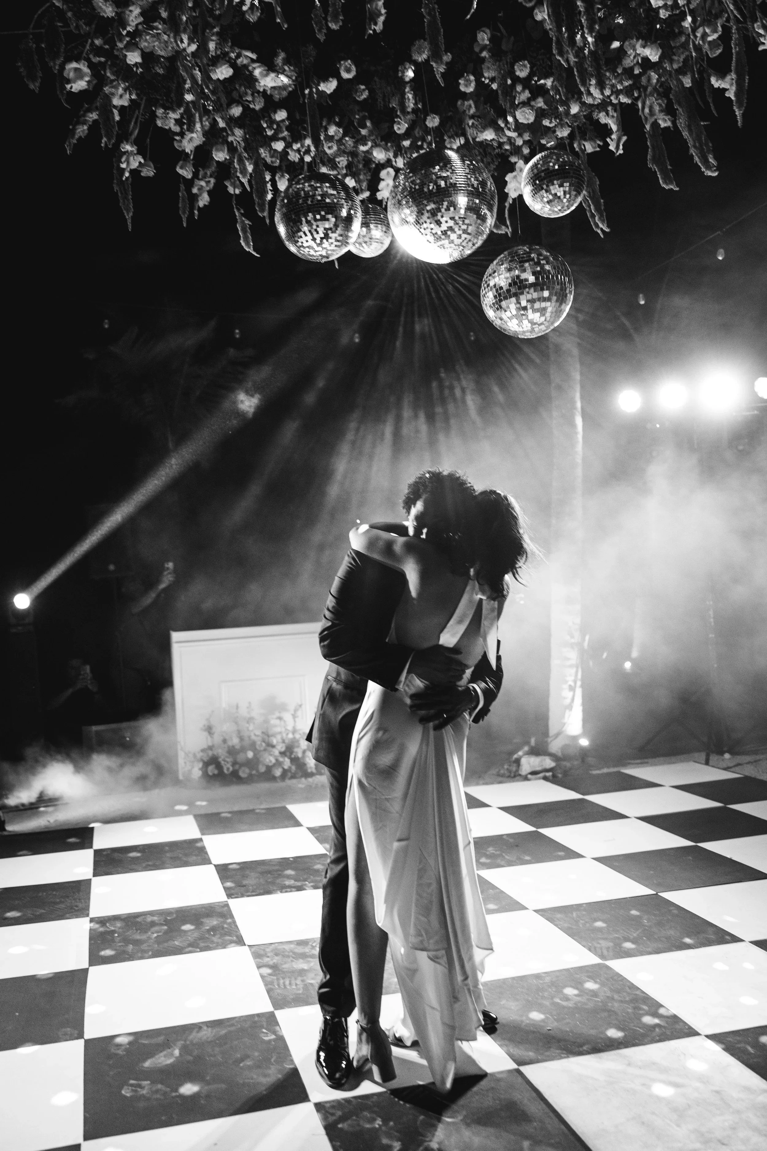 Black and white photo of a wedding first dance with disco balls