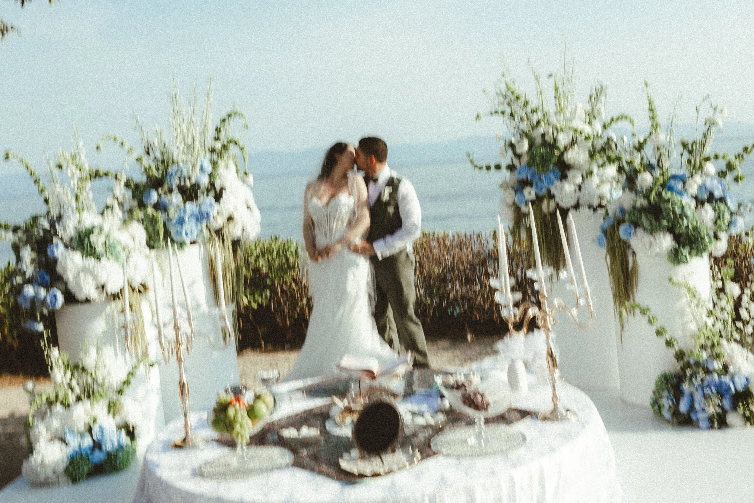 Multicultural Destination Wedding Ceremony in Puerto Vallarta, Mexico. Film Photography of a bride and a groom in a green and blue color palette with the ocean as the backdrop
