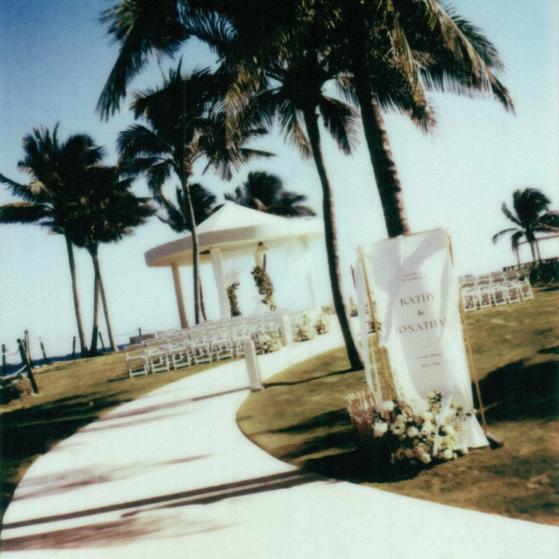 Beach with several tall palm trees and Cancun Hyatt Ziva's beachside wedding gazebo in the background.
