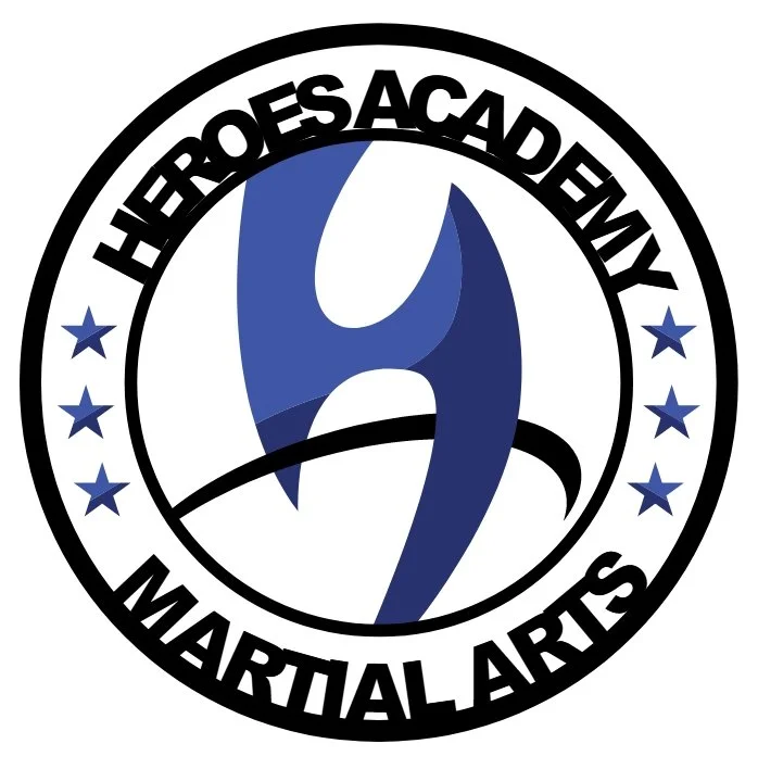 Logo for Heroes Academy Martial Arts featuring a blue stylized figure in a martial arts pose, with stars on either side and text around the circle.