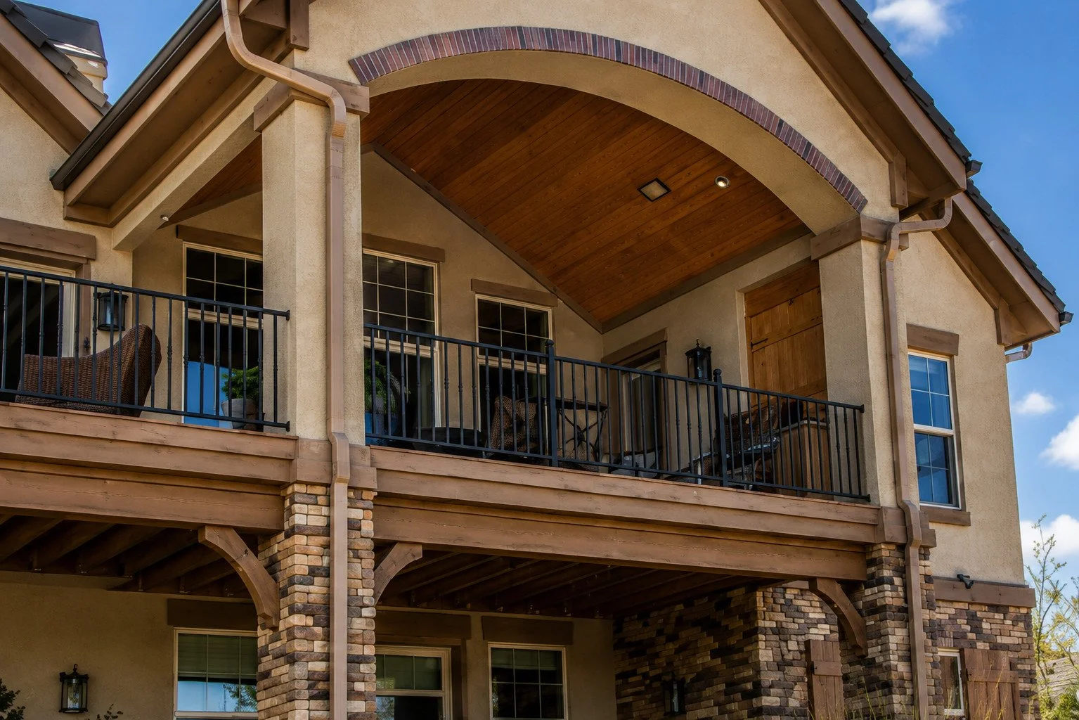 Custom covered deck with wood ceiling, stone columns and black railing, Elizabeth, Colorado