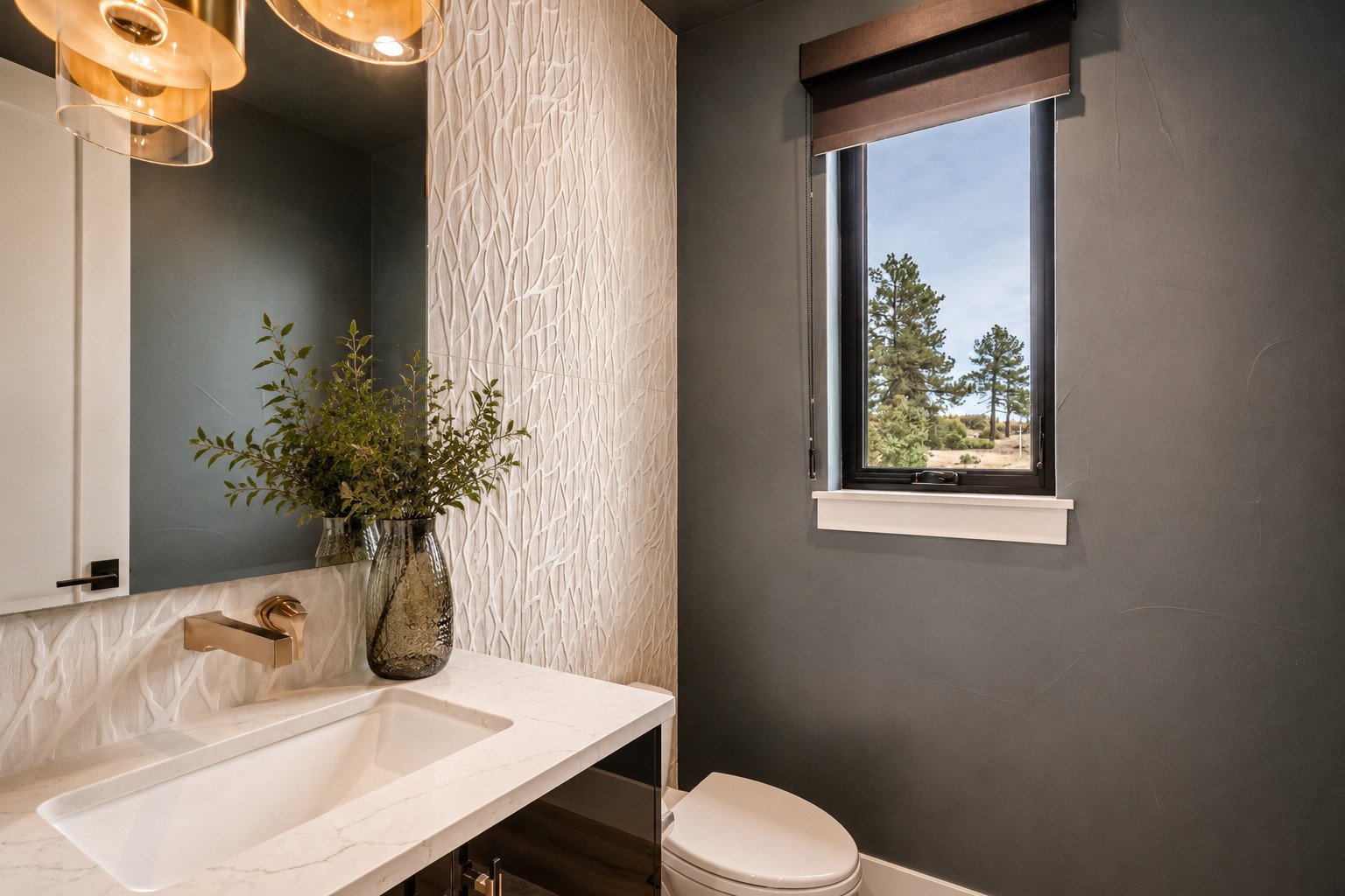 Powder bath with large format tile, brass faucet on dark walls, Colorado