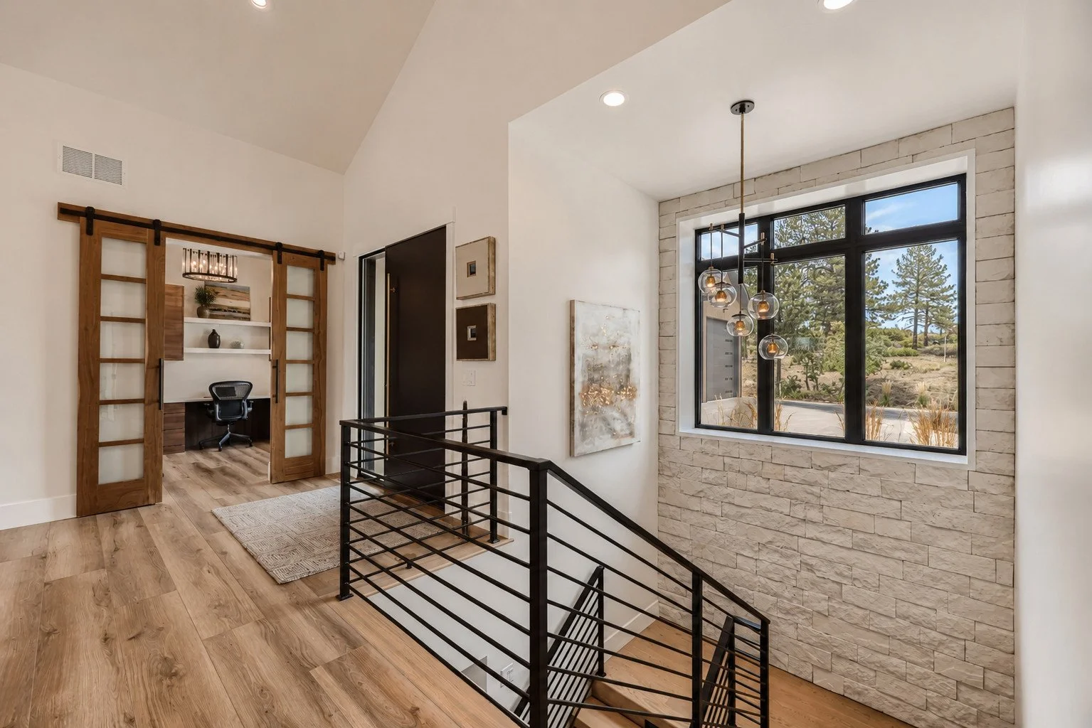 Entry landing with staircase and sliding walnut barn door office, Franktown, Colorado