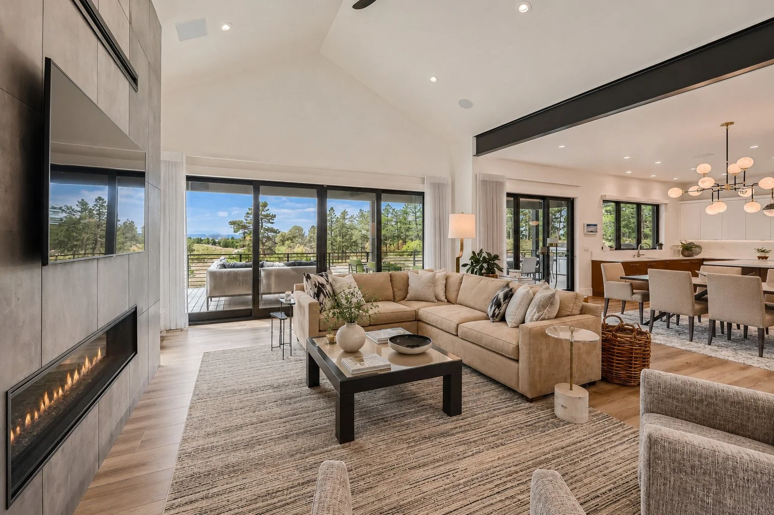 Open living room with vaulted ceiling, exposed beams and expansive sliding glass doors, Franktown, Colorado
