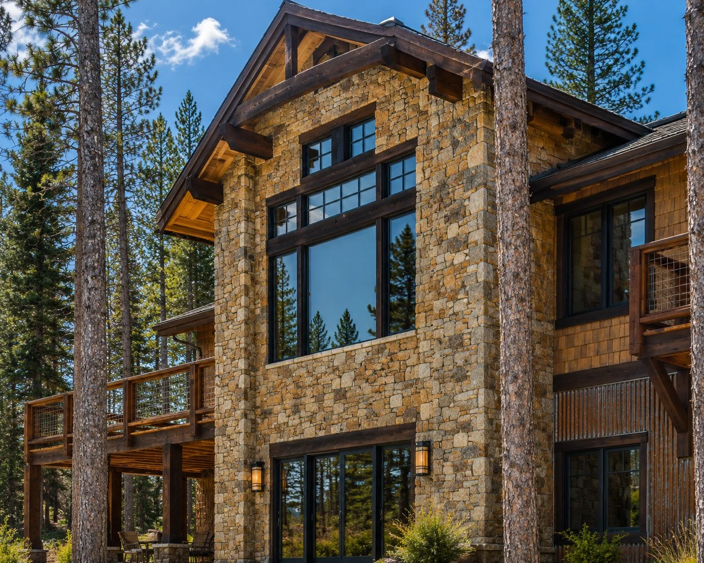 Mountain home with stone facade, wood balconies, rusted corrugated siding and large windows, Fraser, Colorado