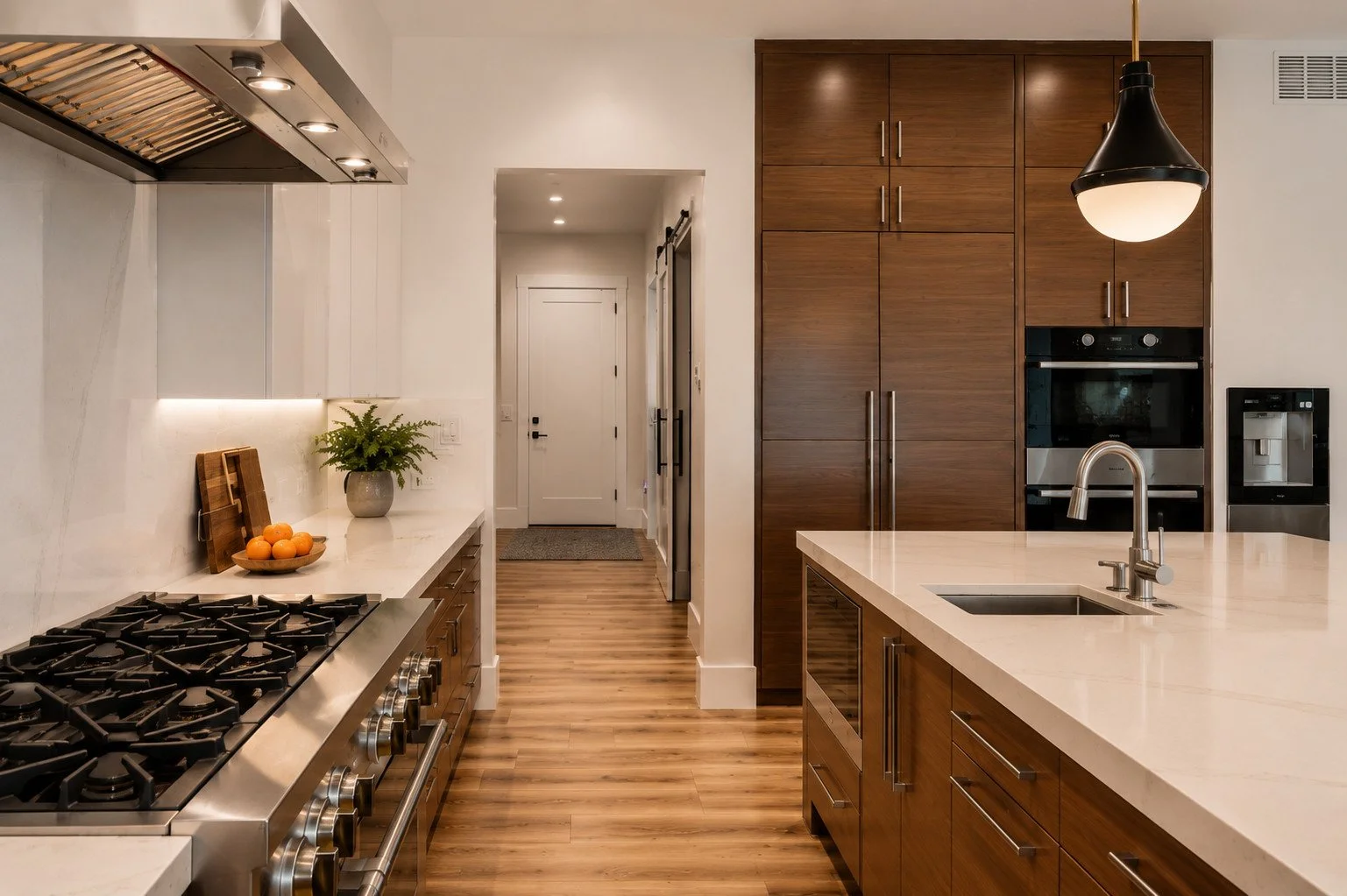 Kitchen with steel range shroud, island sink and pendant lighting, Franktown, Colorado