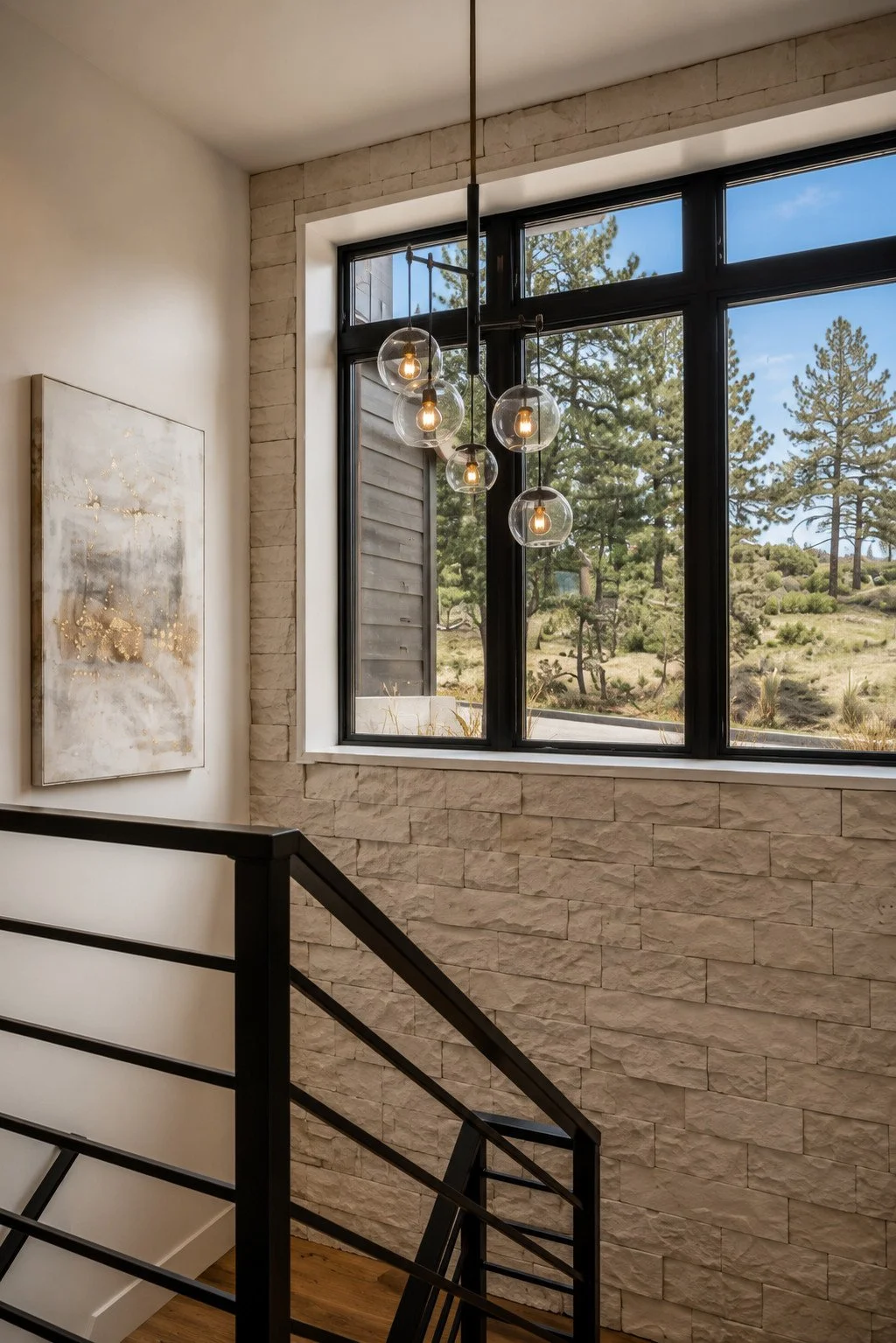 Modern rustic stairwell with stone accent wall, Franktown, Colorado