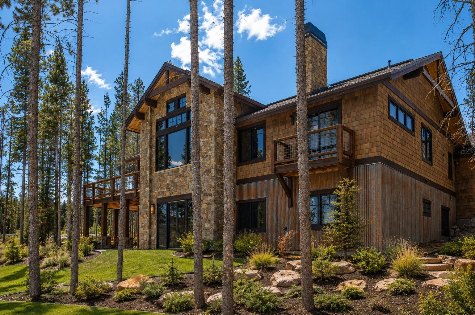 Colorado mountain custom home with natural stone, wood exterior, balconies and expansive windows, Fraser, Colorado