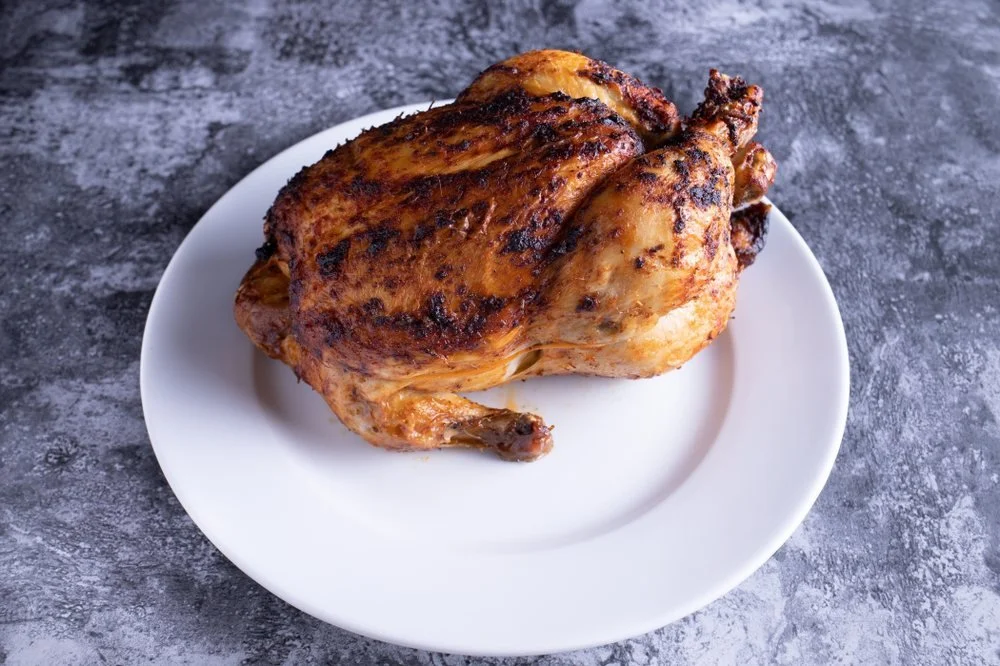 Cooked roasted chicken on a white plate