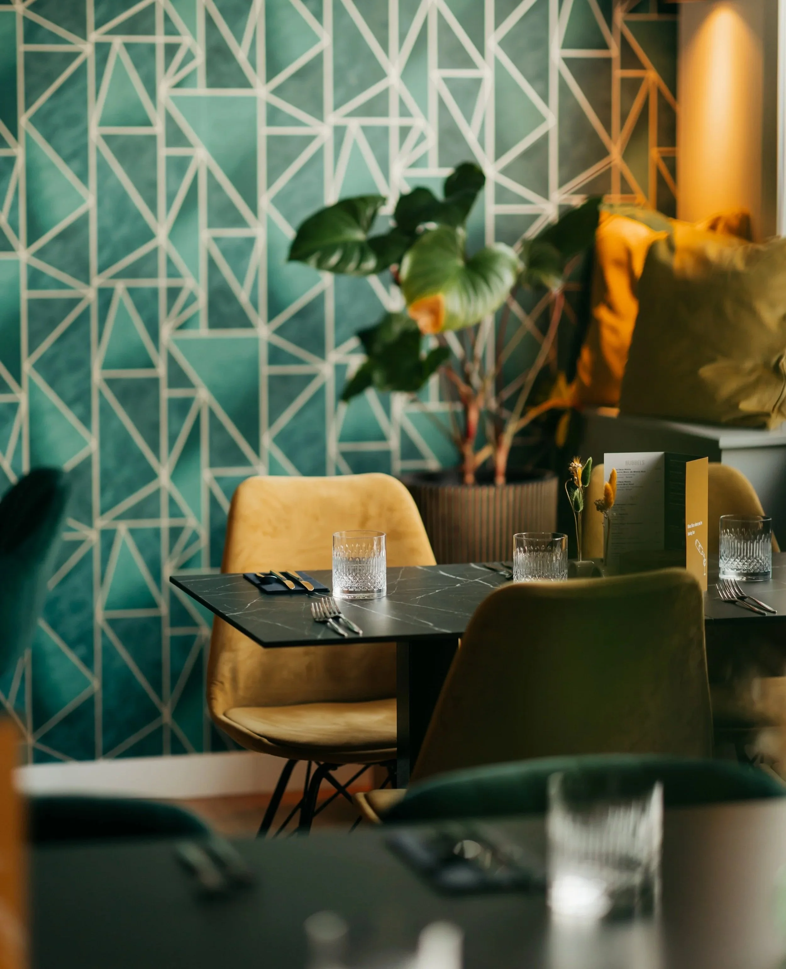 Een modern interieur met zachte stoelen en een gedekte tafel.