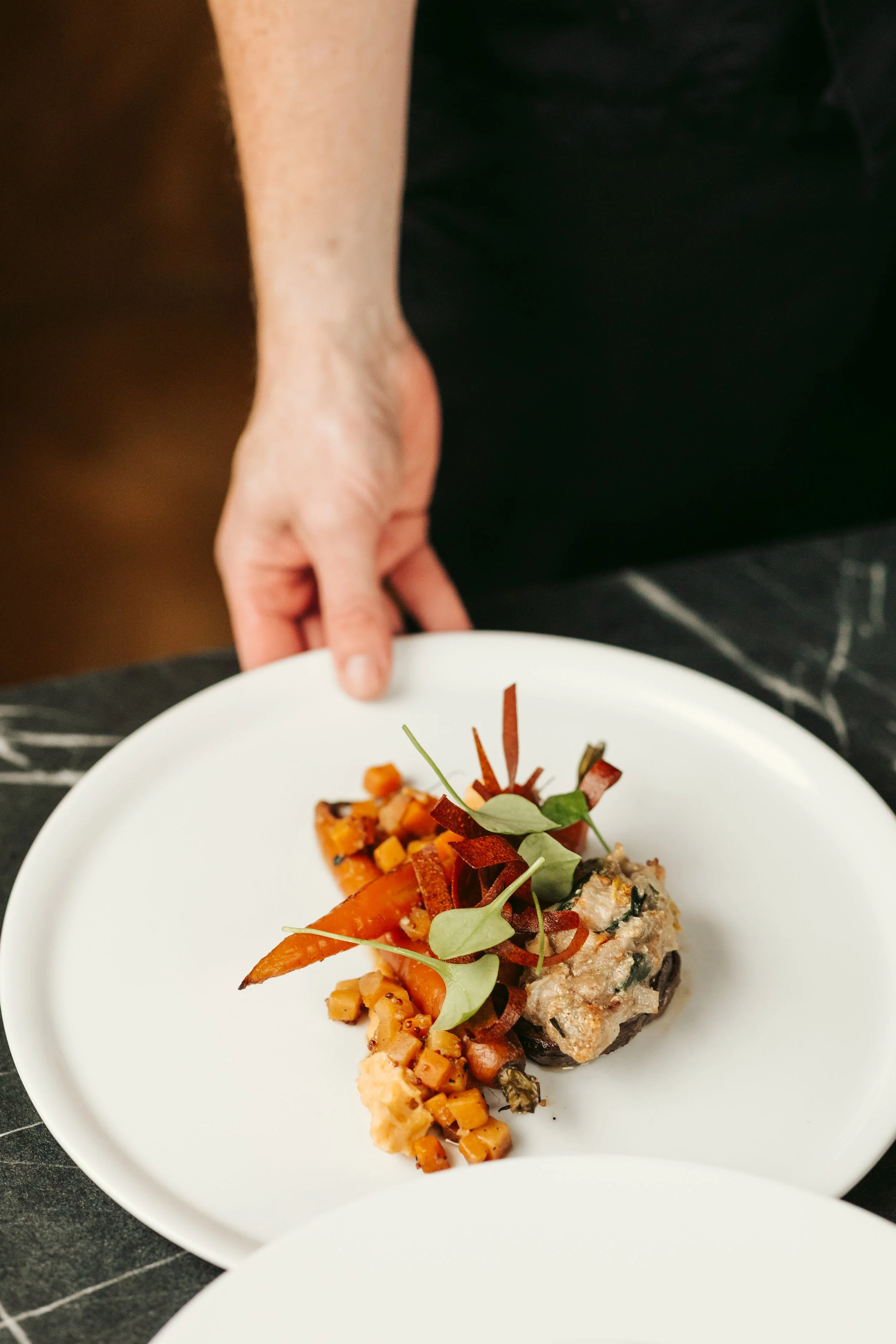 Els die een bord vasthoudt met een vegetarisch gerecht uit de smaakmenu's