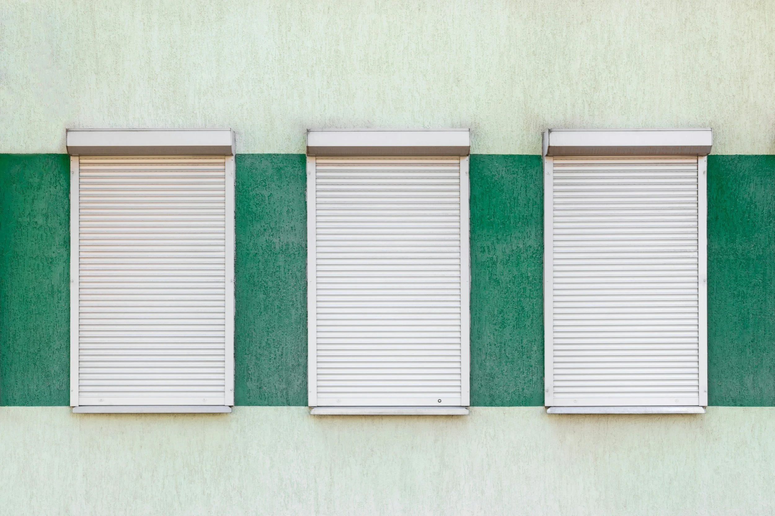 Florida homeowners preparing their home with hurricane shutters before a storm.