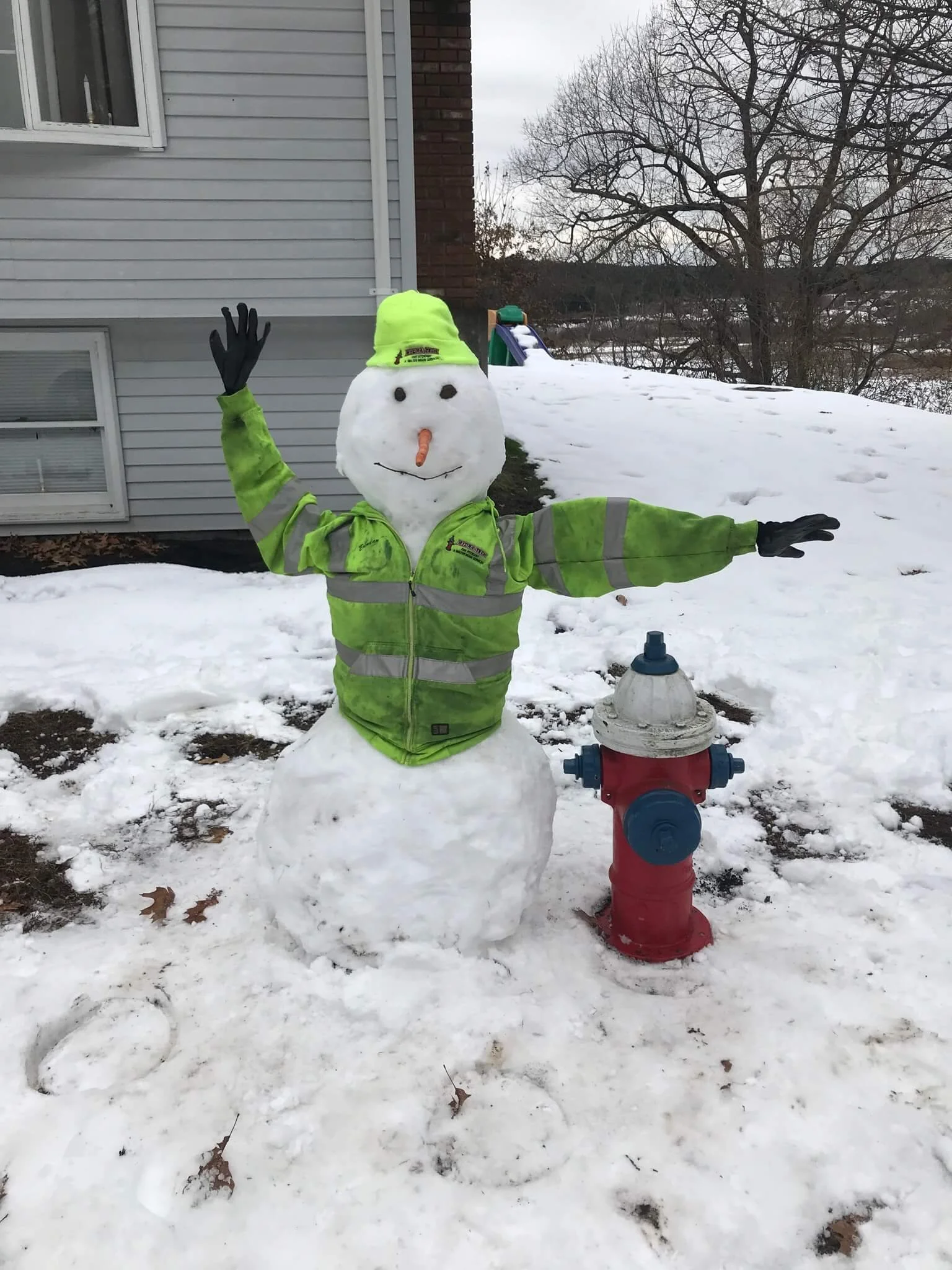 Snowman dressed as a HydraTech employee and a hydrant.