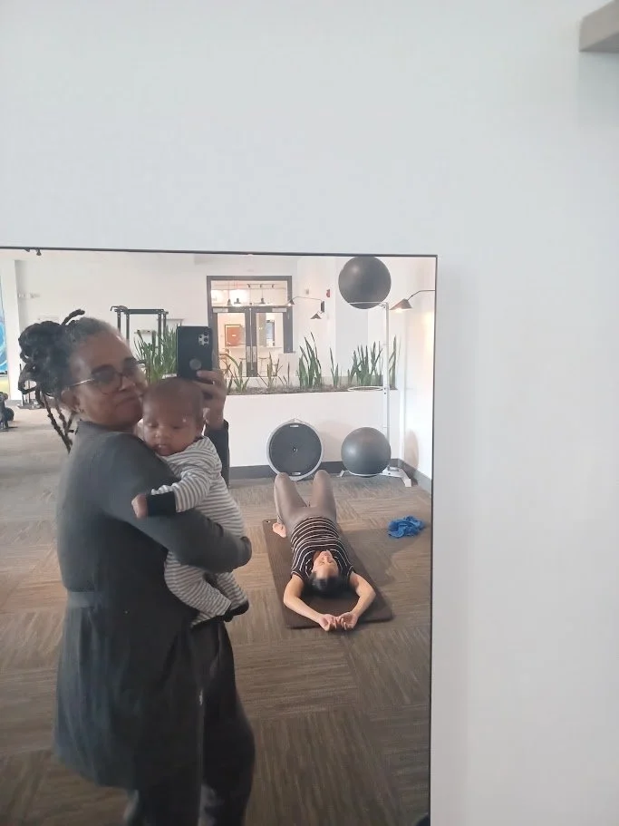 A woman taking a mirror selfie while holding a baby, and a person lying on a yoga mat in a gym.