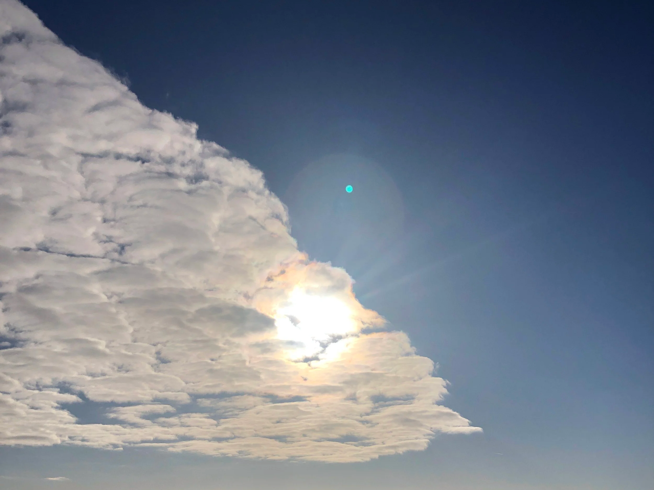 Sonne scheint durch Wolke am Himmel
